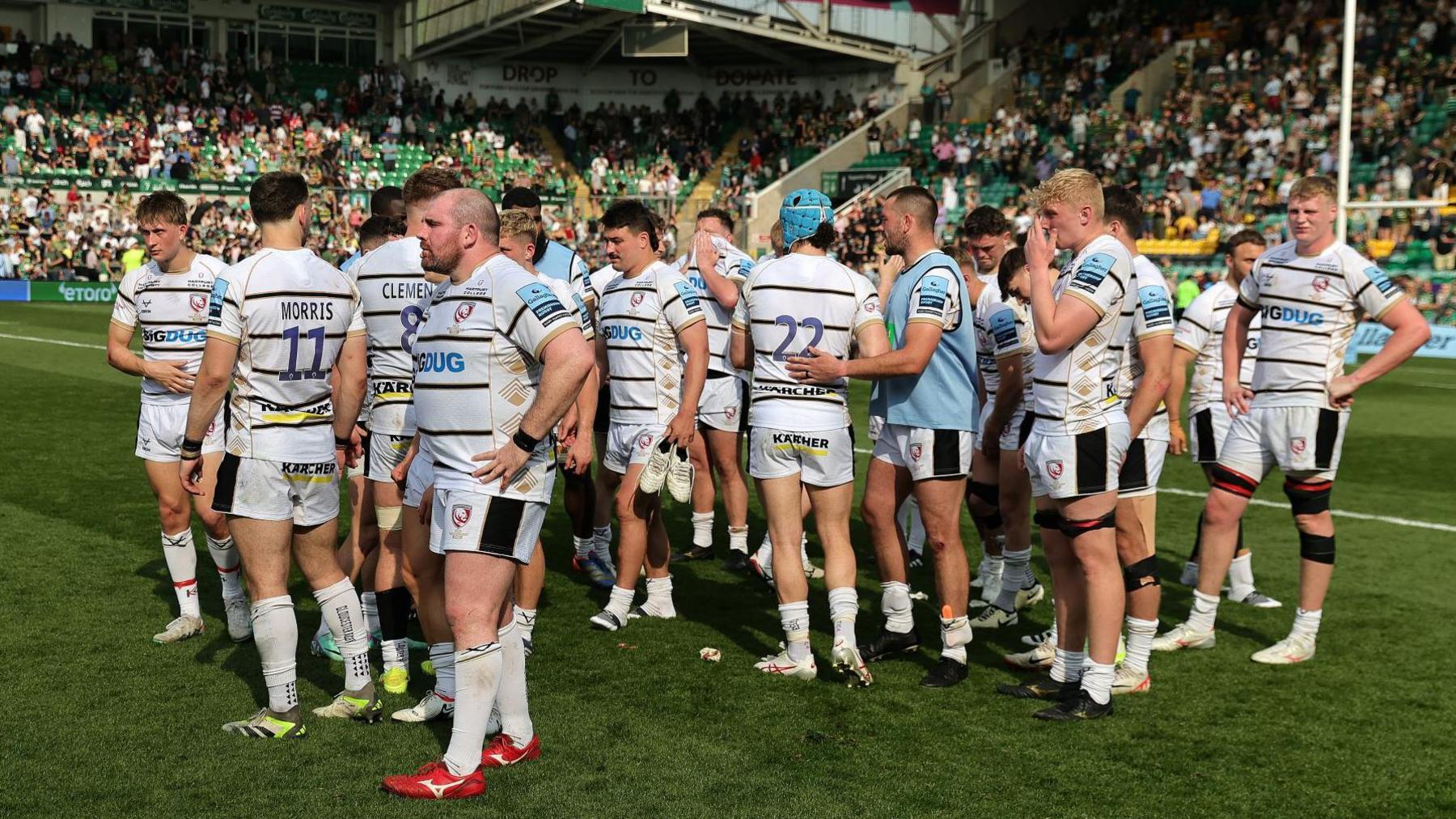 Gloucester players gather on the pitch after the 90-0 defeat by Northampton