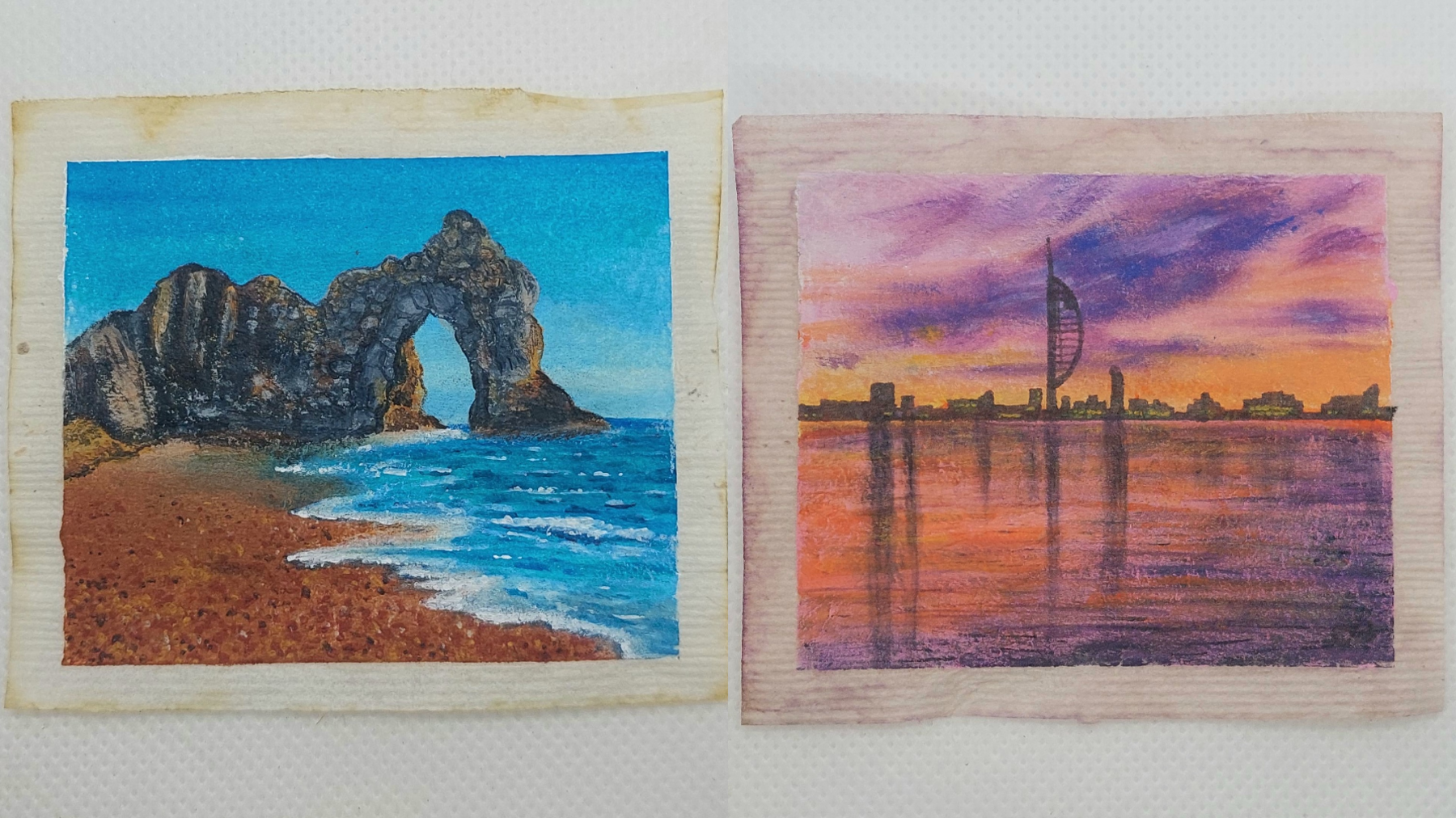 Two flattened teabags - one has Durdle Door with grey rocks, golden sand and bright, blue sea painted on it, while the other has the Spinnaker Tower in silhouette with a purple and orange sky reflected in the water painted on it