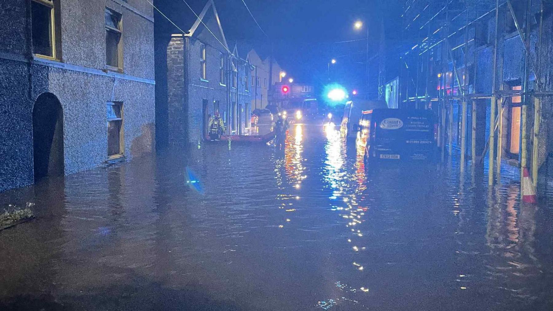 Llun o'r llifogydd ar y stryd yn y tywyllwch.