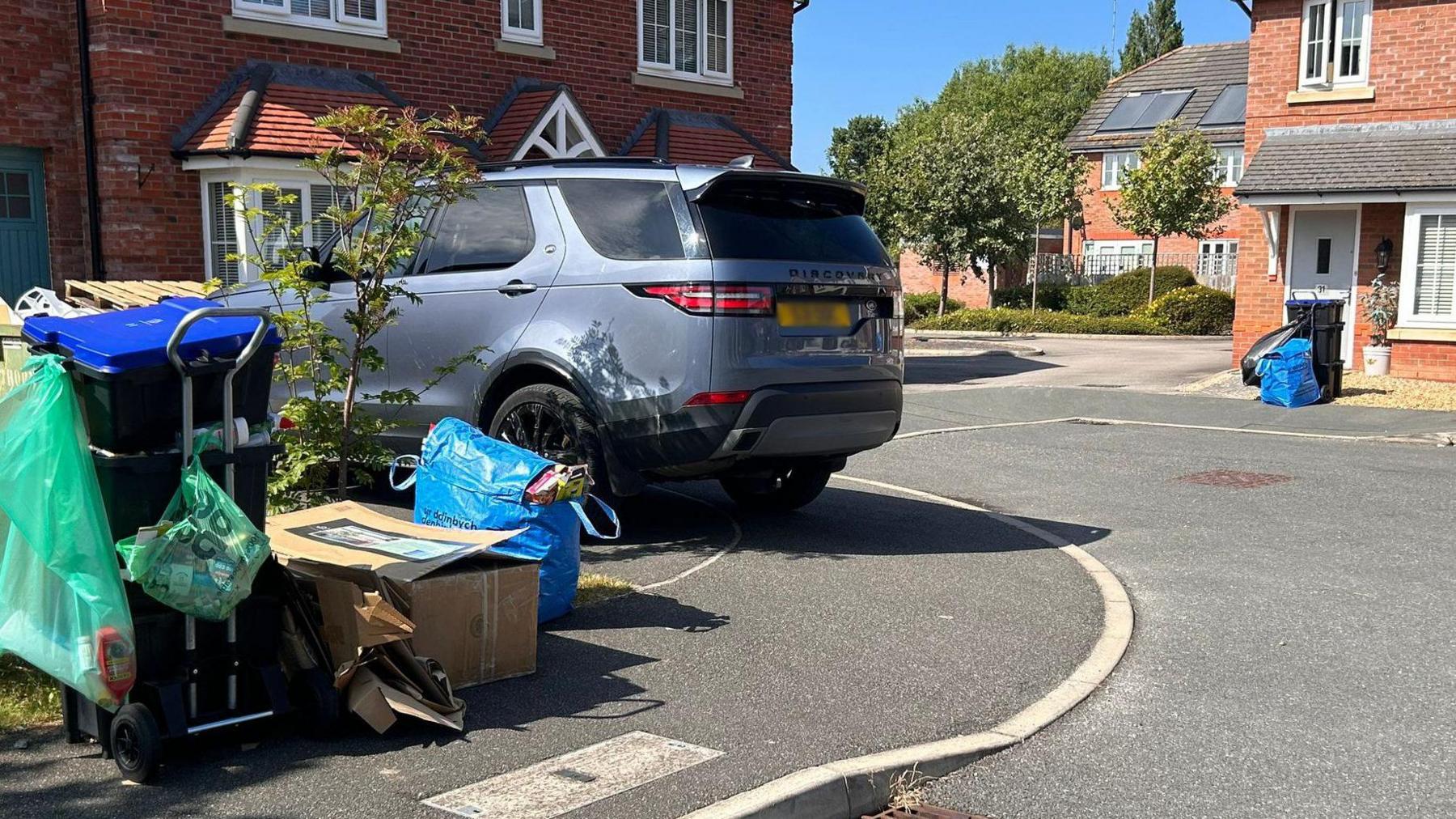 Uncollected rubbish bins outside houses in a Denbighshire street