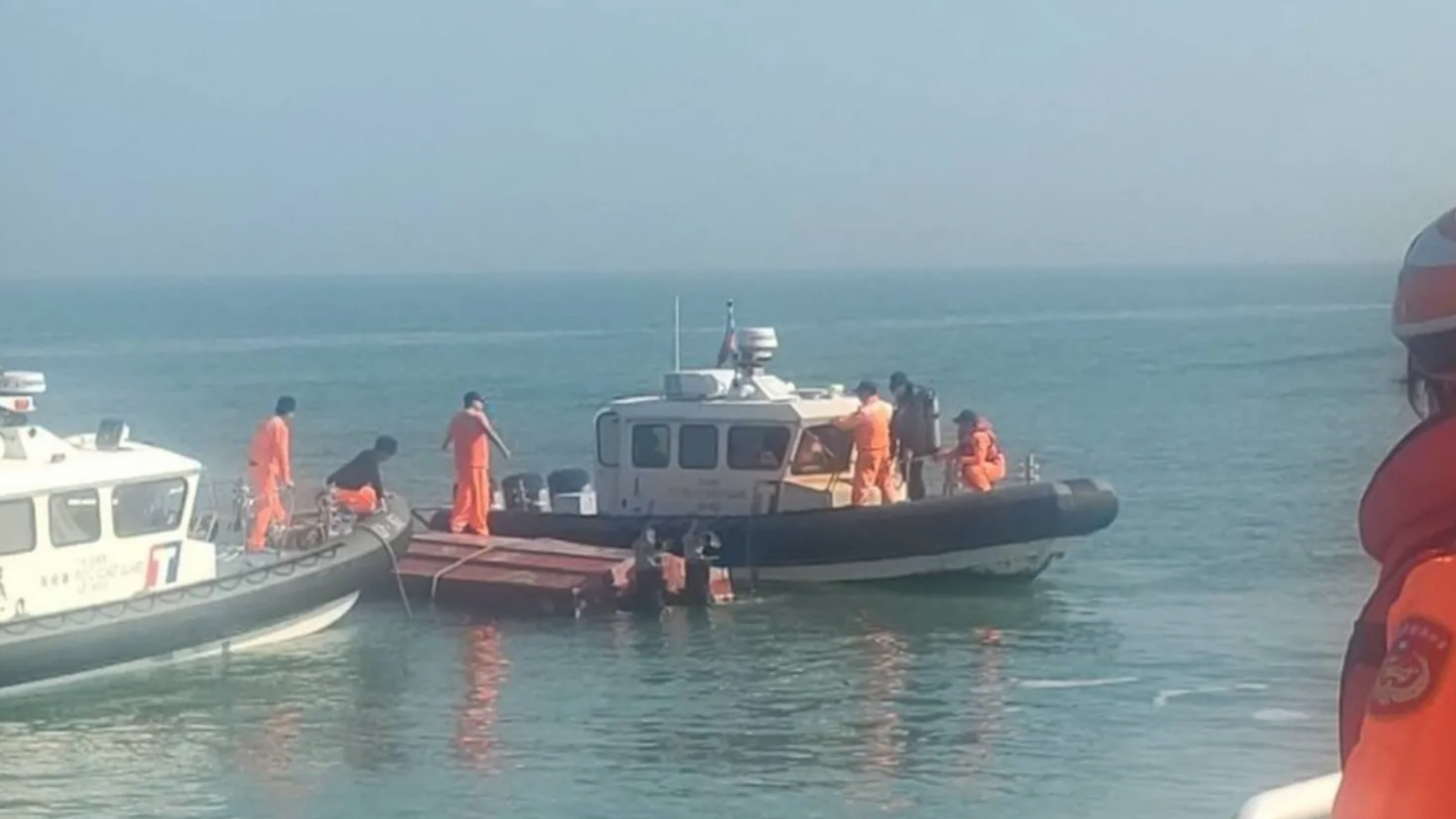 Taiwanese coast guards inspect the vessel that capsized during a chase off the coast of Kinmen in February