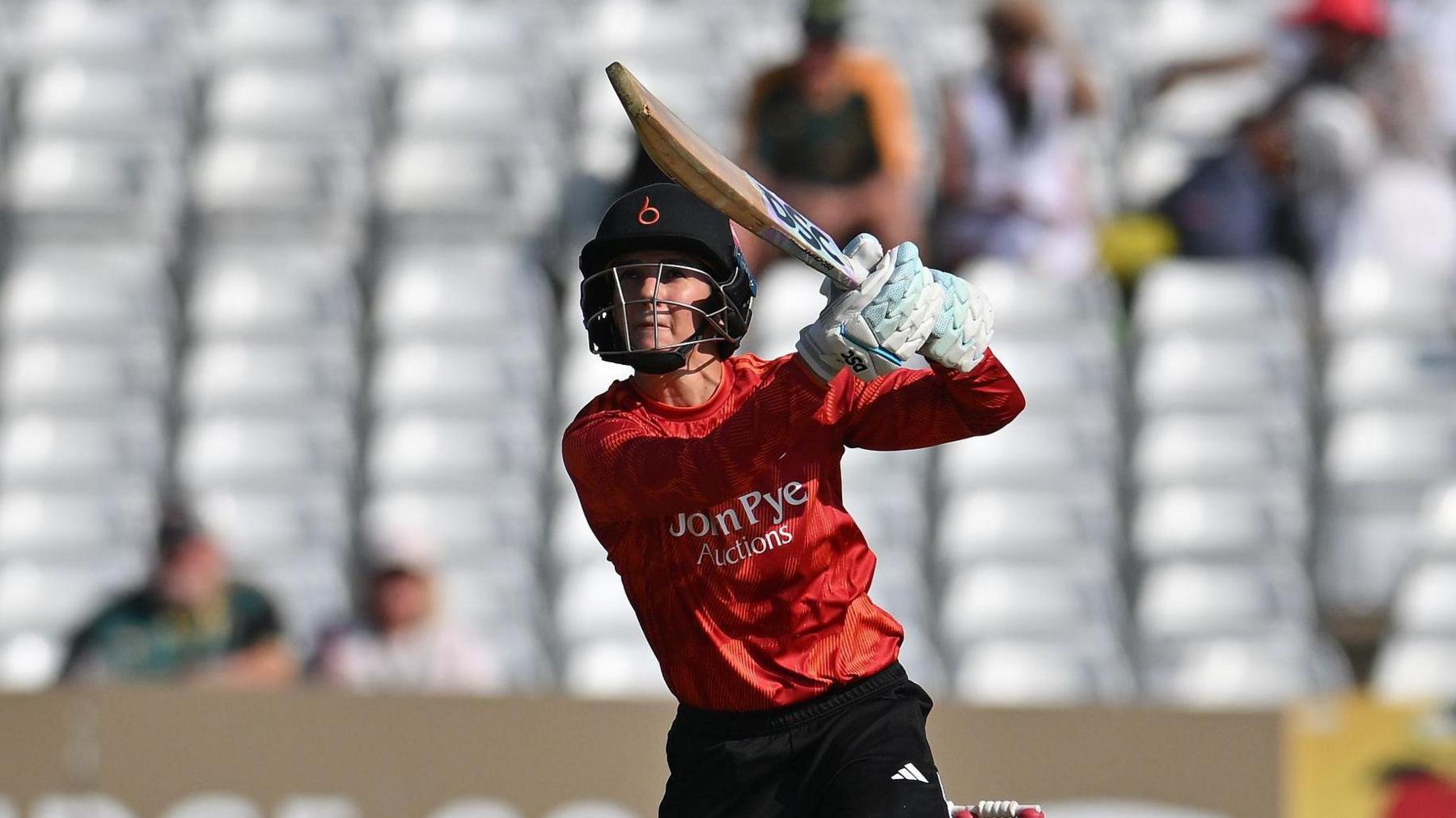 Australian Charli Knott playing for The Blaze, batting with a navy helmet on