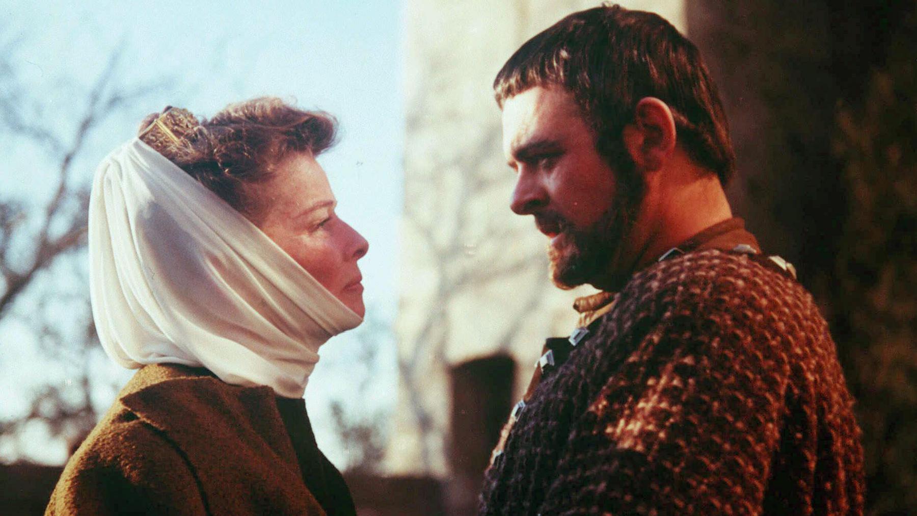 On the left is profile of Katherine Hepburn as Eleanor of Aquitaine with with white chiffon scarf around her head and brown dress
looking at Hopkins (playing Richard the Lionheart), in his first film The Lion in Winter with dark hair and beard and brown outfit