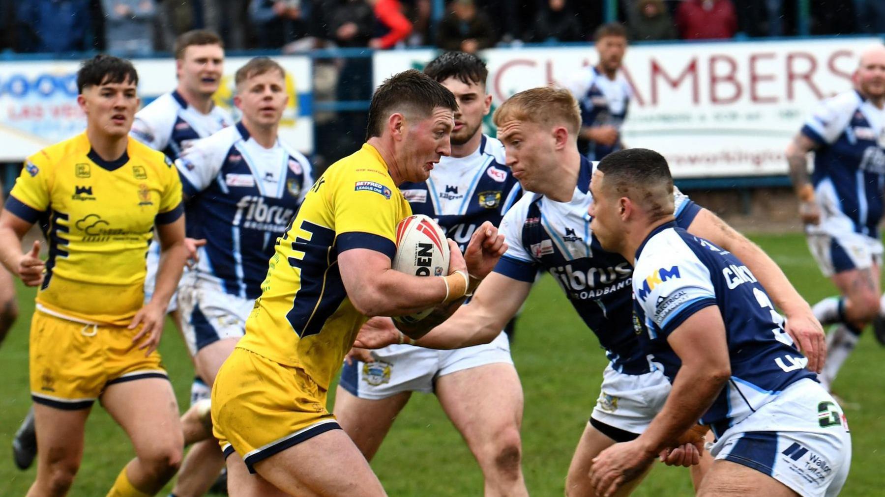 Whitehaven (in yellow) taking on Workington in navy blue and white on Good Friday