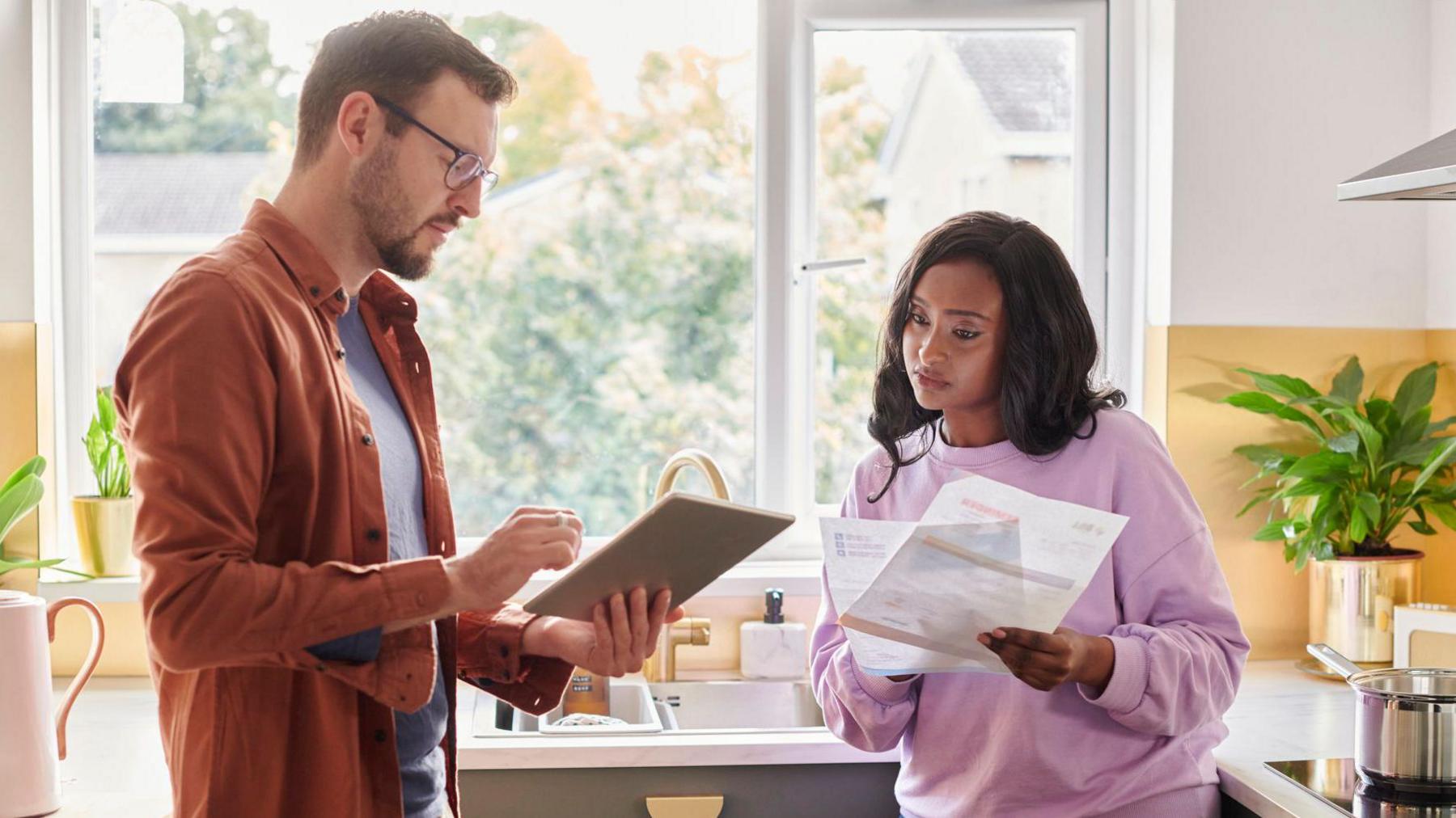 A couple looking at energy bills in their kitchen