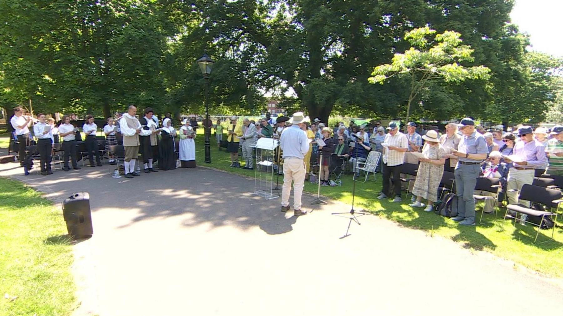 The Lord Mayor, councillors, clergy, school children and members of the public outside in Watts Park Southampton, some with instruments and some singing hymns