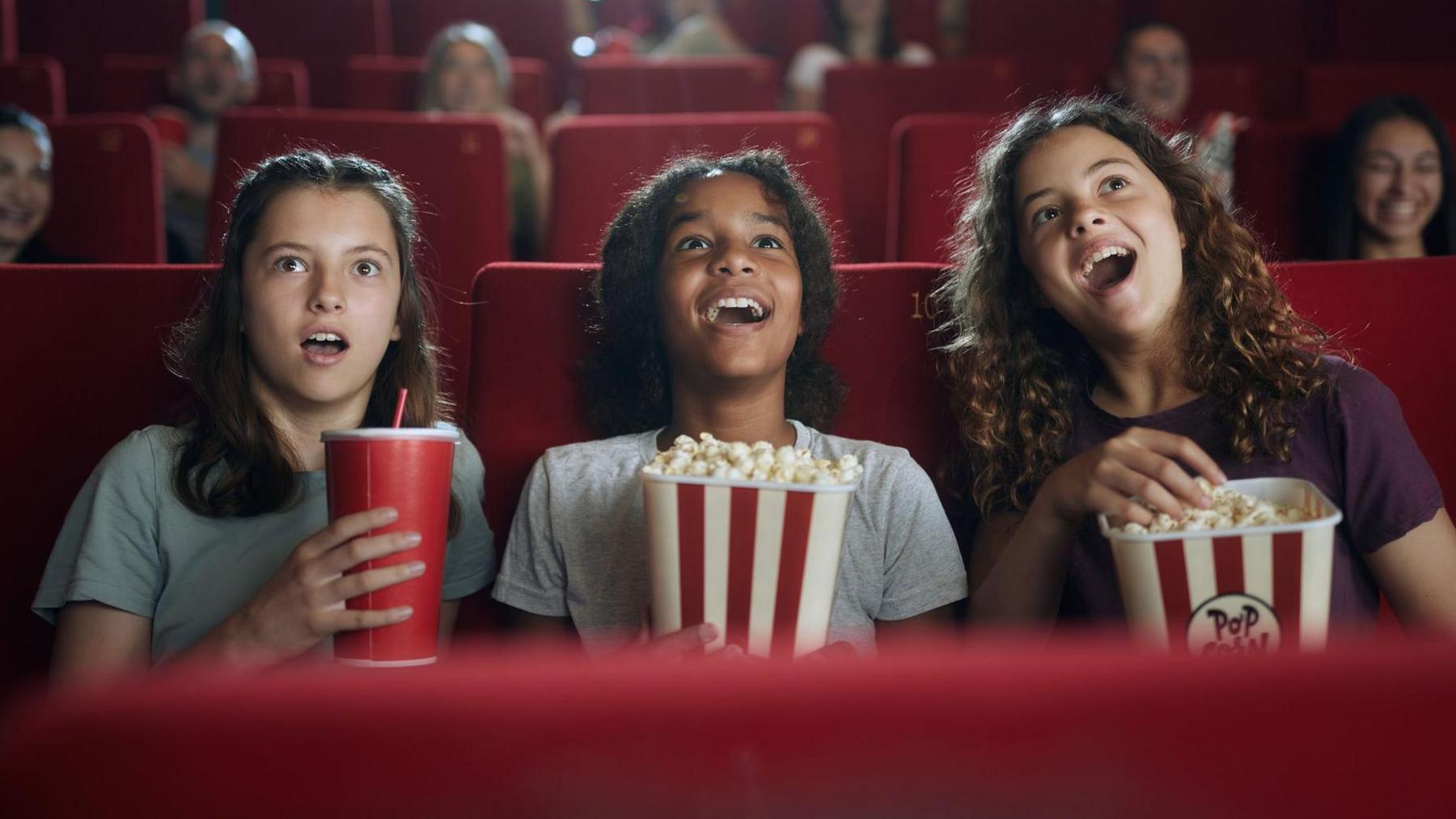 children in the cinema eating popcorn