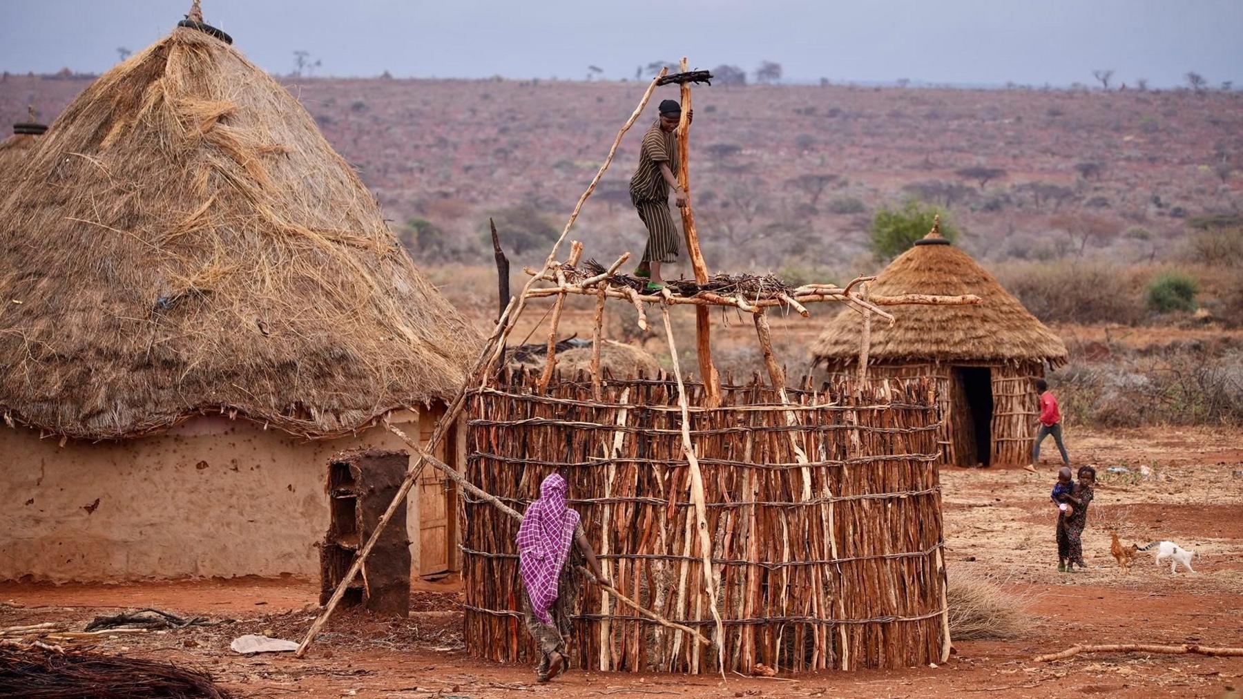 Borana women in southern Ethiopia building huts from wood, mud and straw