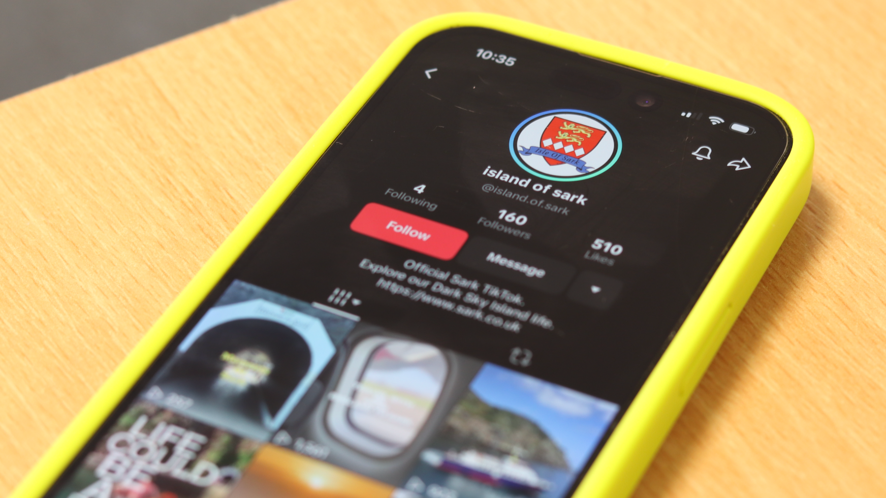 Isle of Sark TikTok page on the screen of an iPhone which is in a yellow phone case on a desk.