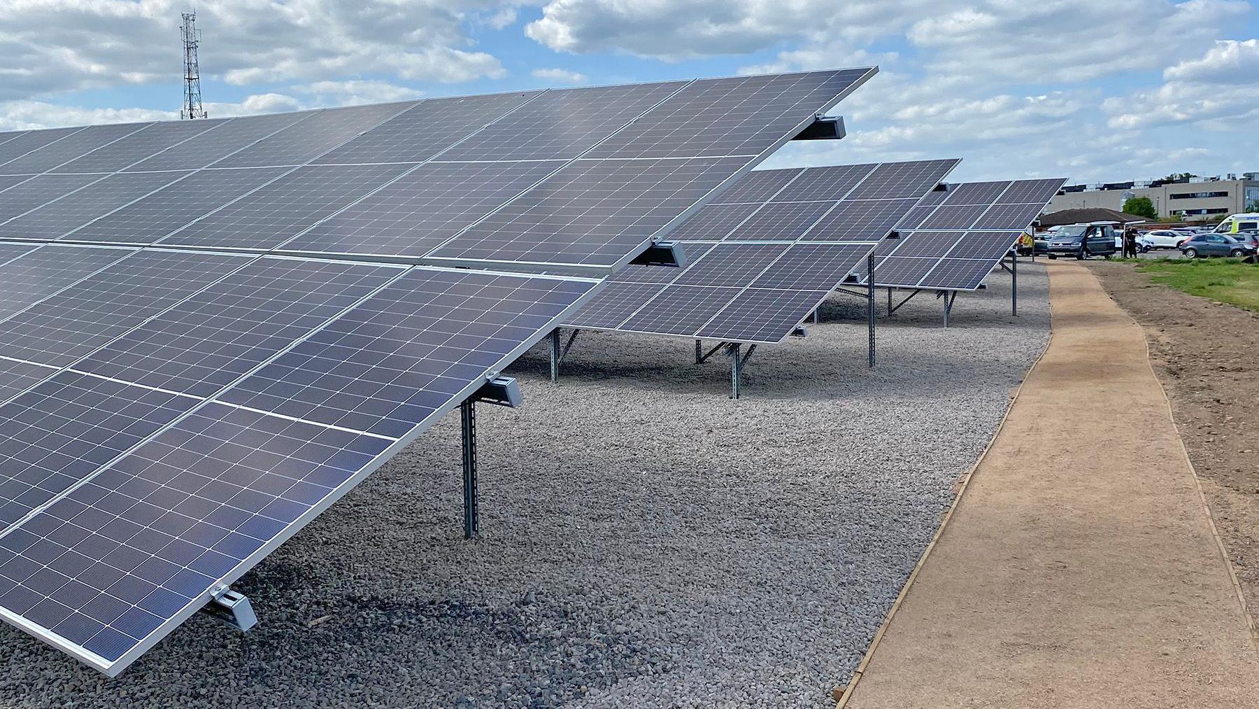 Solar panels on a gravel path.