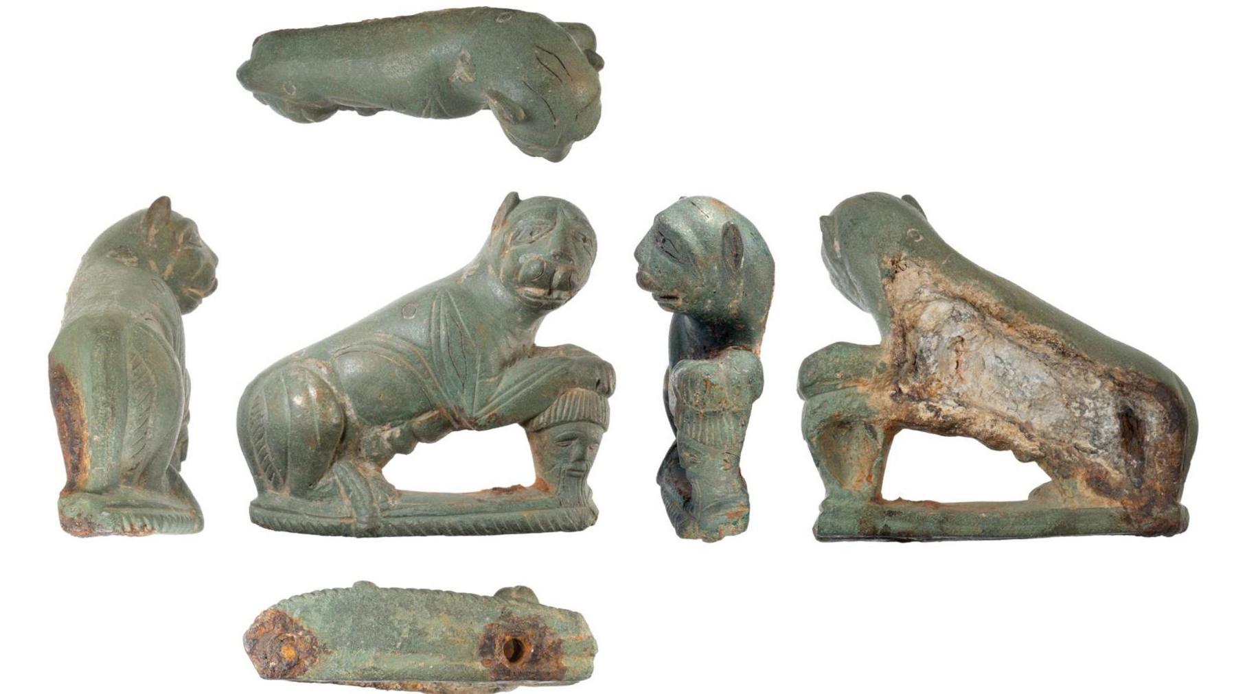 Six views of a Roman-era panther, made from copper alloy, and resting on its haunches with its front paws on the severed head of a bearded man. Its head is turned to its right.