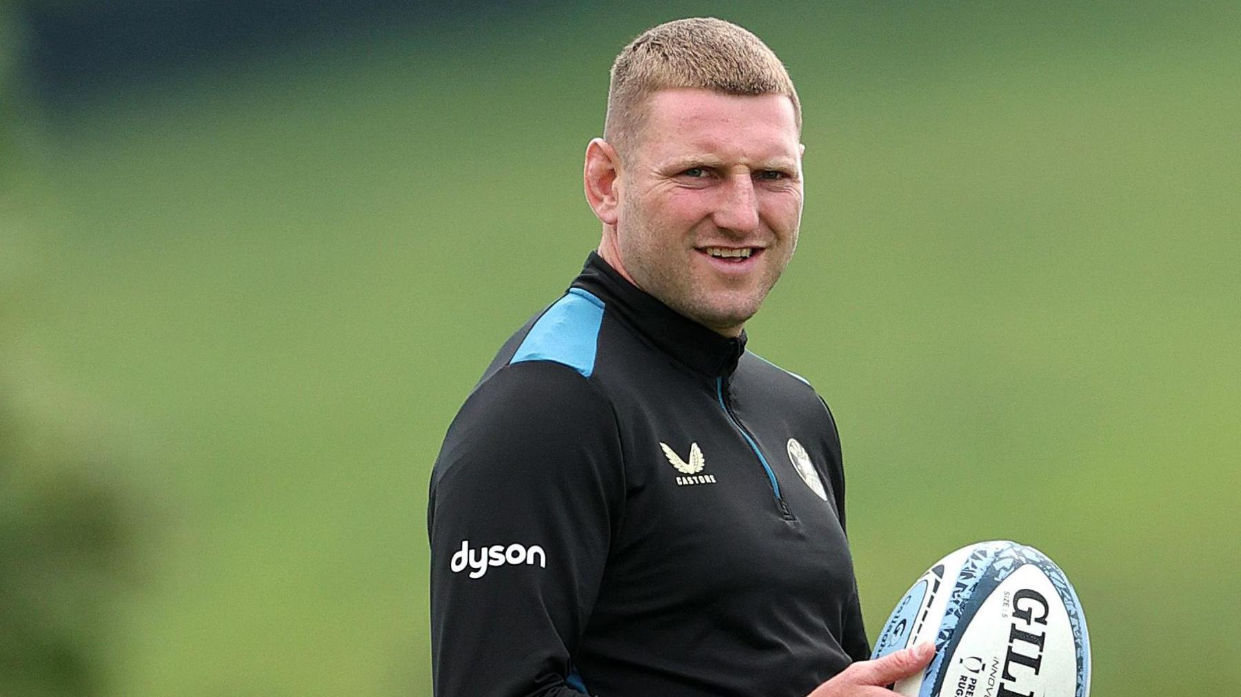 Finn Russell holds a rugby ball during training