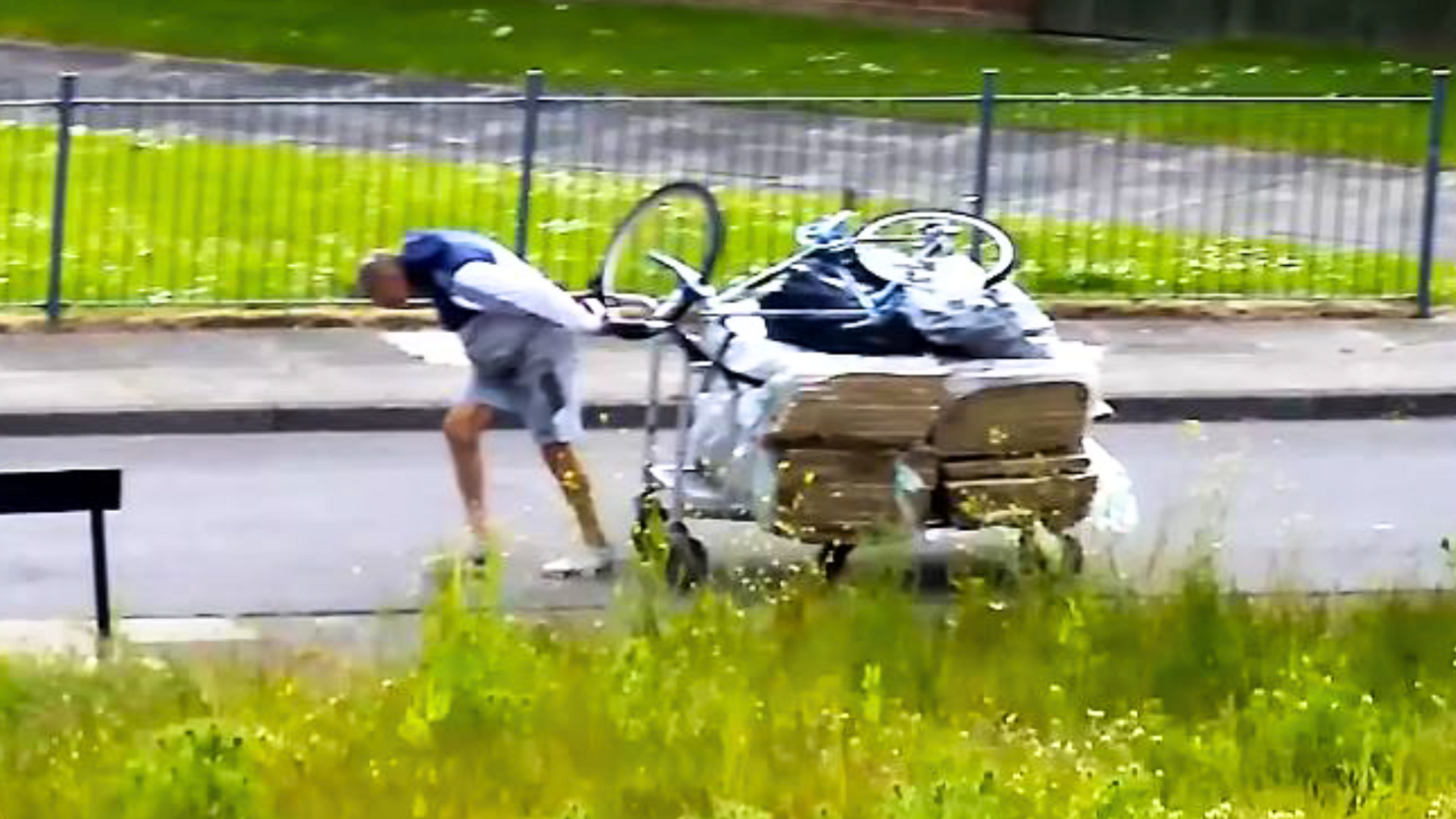 A man drags rubbish on a trolley