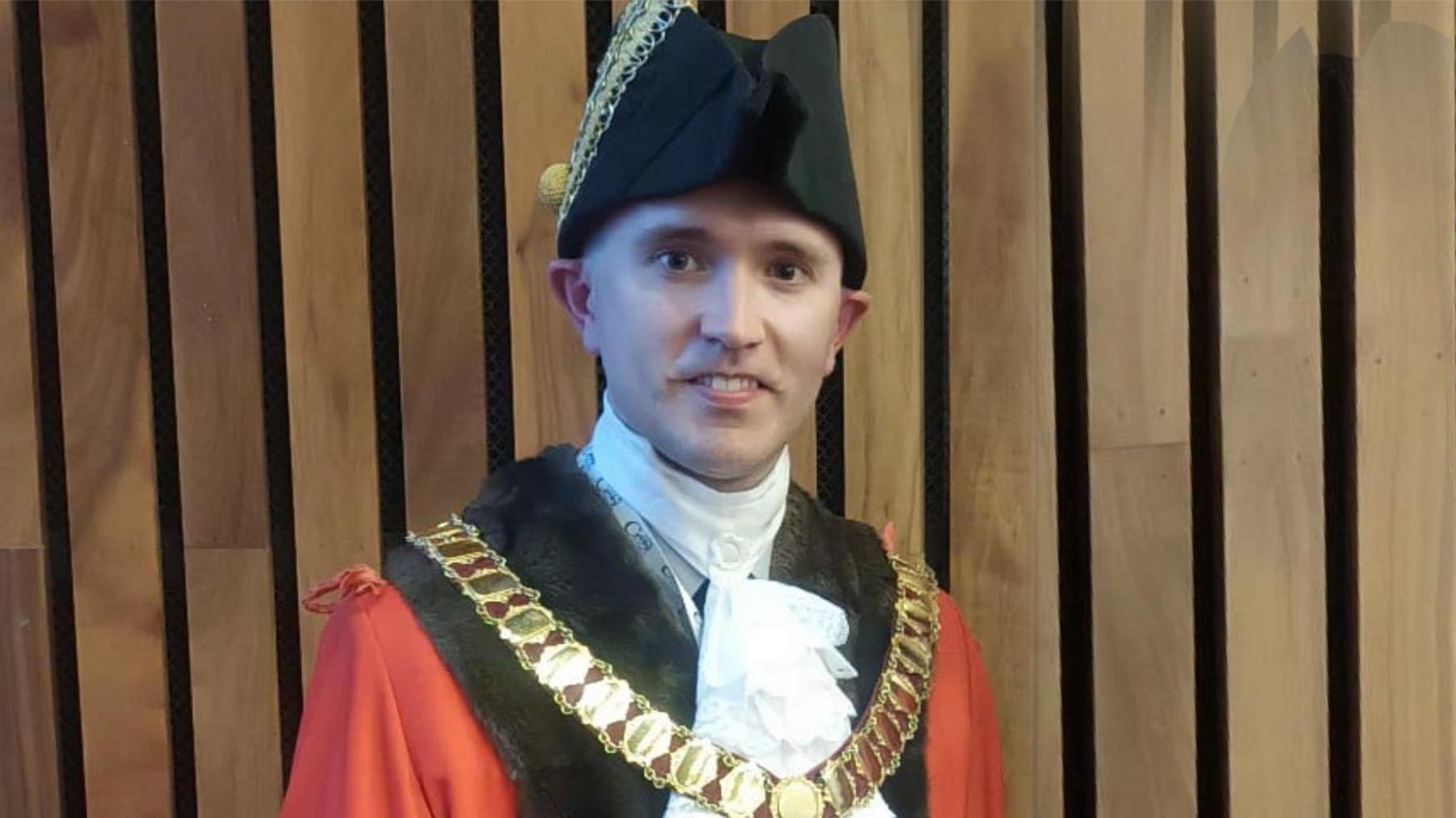 Ross Armour wearing a black bicorne hat and a red and black robe with a mayor's chain of office