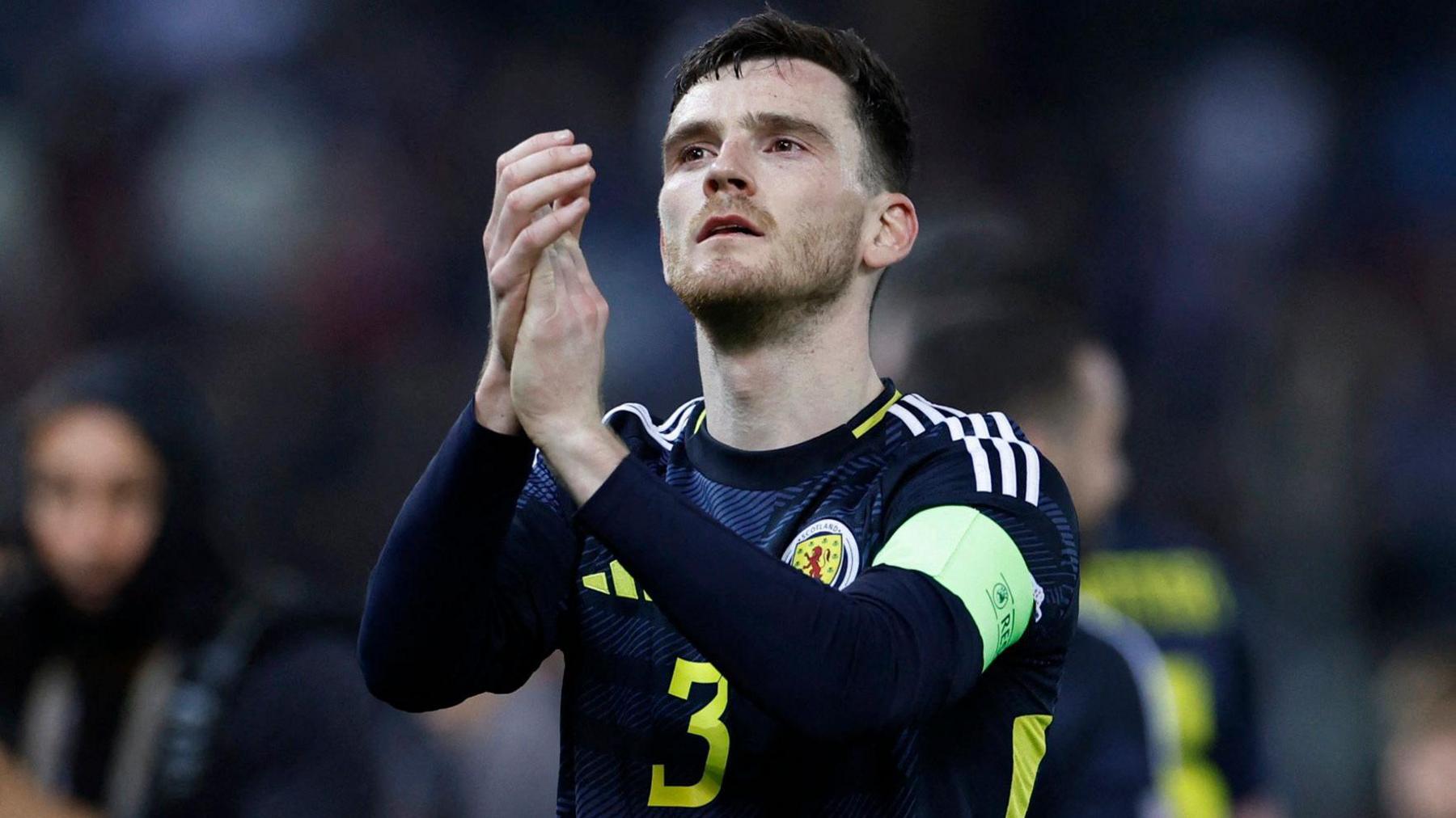 Andy Robertson applauds wearing a Scotland shirt