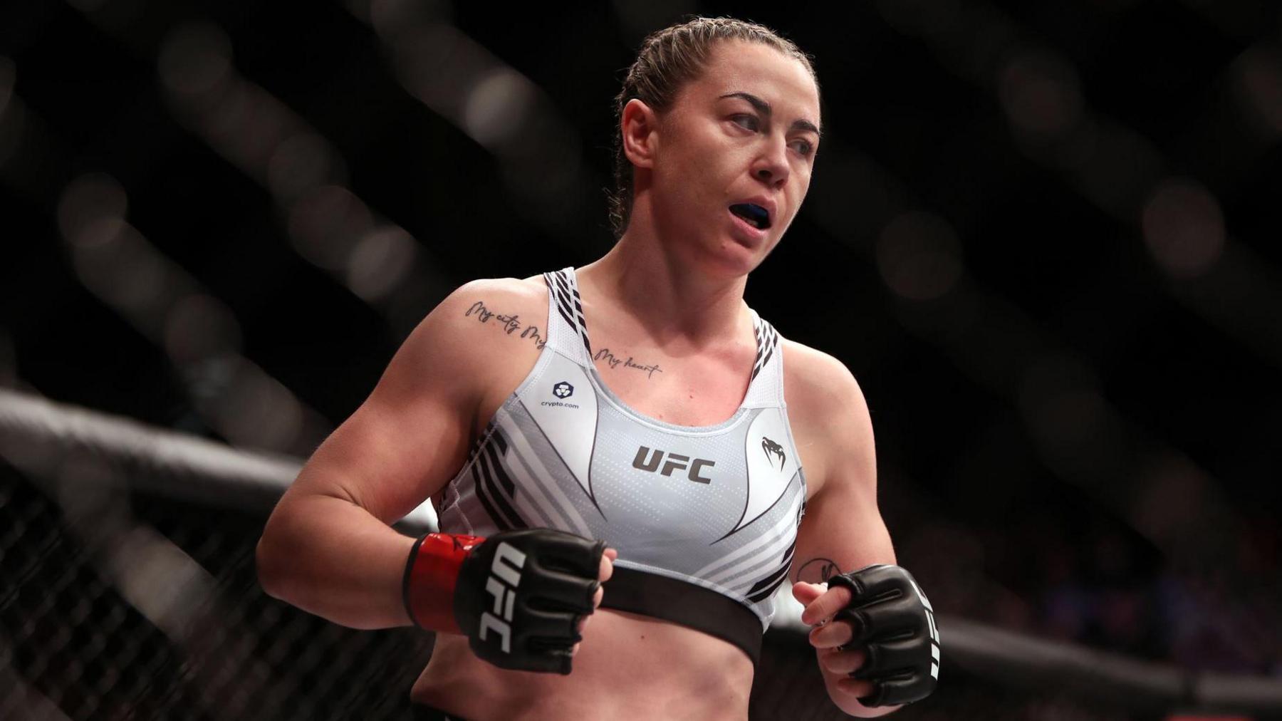 Molly McCann, wearing a white and grey sports vest with UFC branding in black writing.
