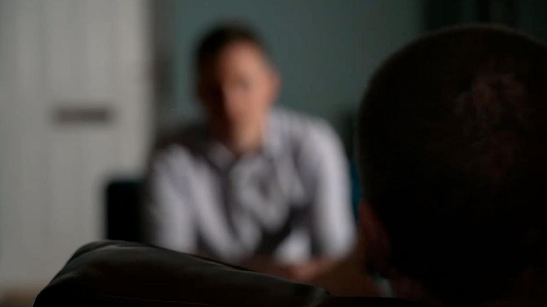 An image of a man doing an interview but the camera is deliberately out of focus. 