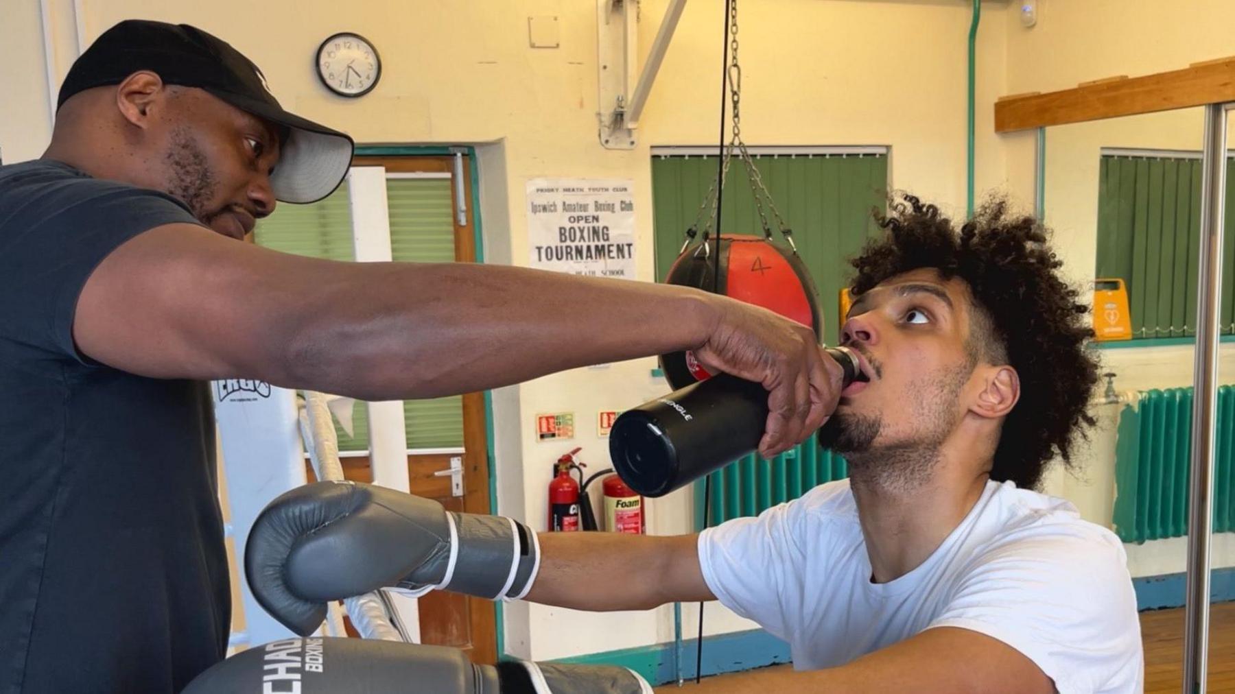 Ottley and Gordon during a training session in Ipswich. His coach is pouring a drink into his mouth