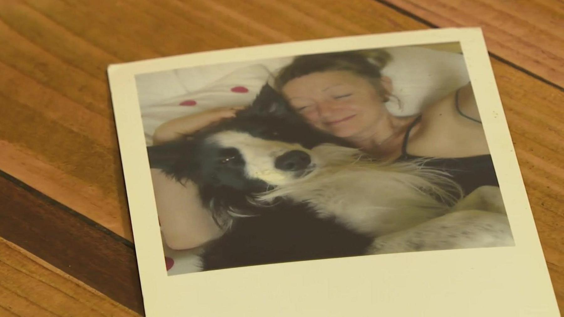 A polaroid picture of a woman cuddling her dog