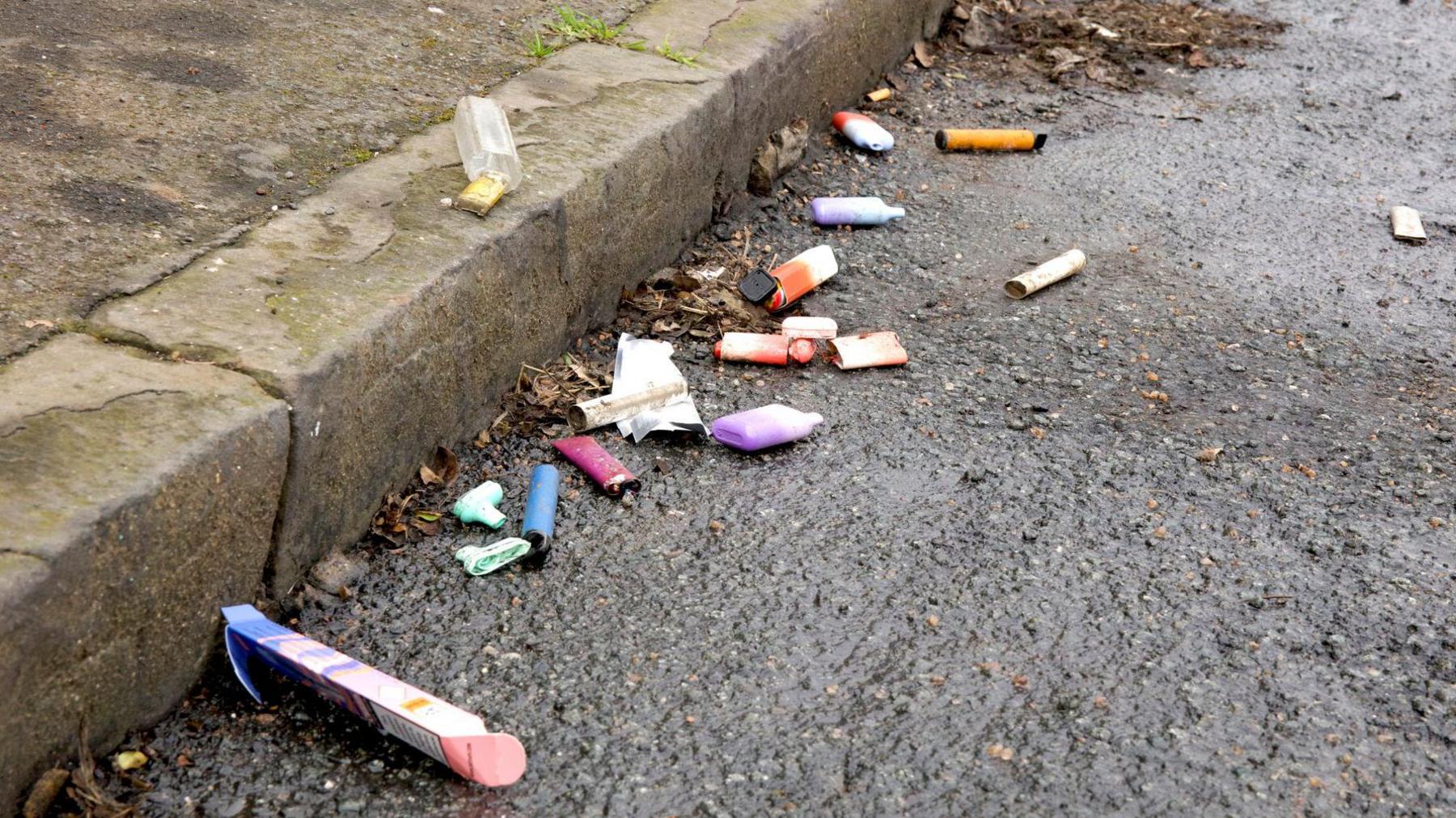 File image showing several disposable vapes and their packaging lying on the side of a road in Kingston-upon-Thames, London