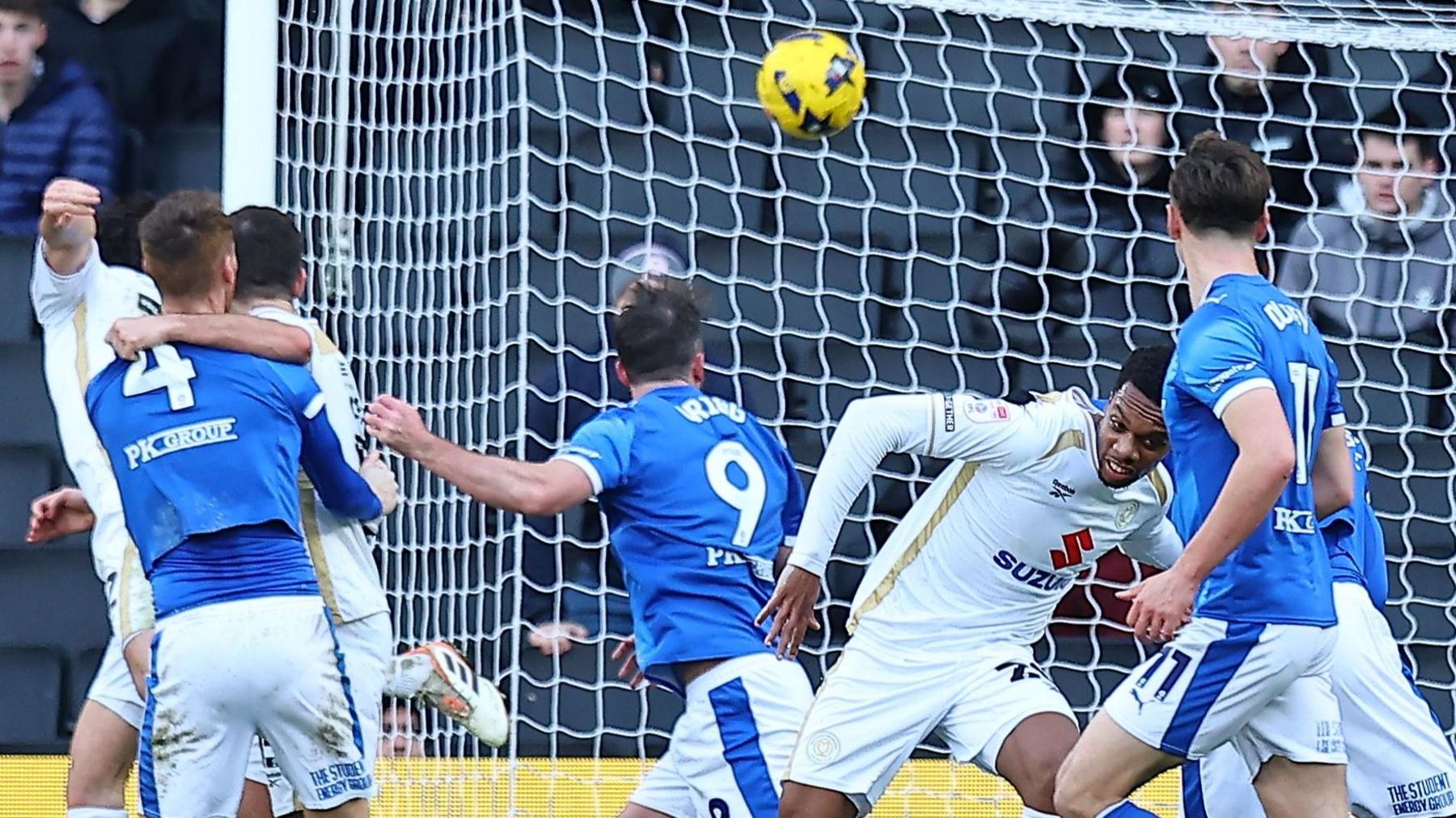 Will Grigg (Number 9) heads in Chesterfield's equaliser at MK Dons