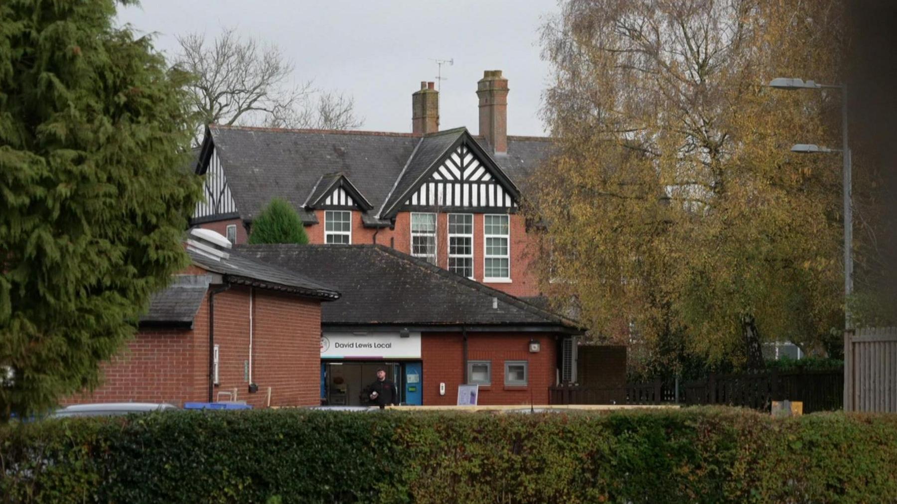 Red brick building surrounded by trees.