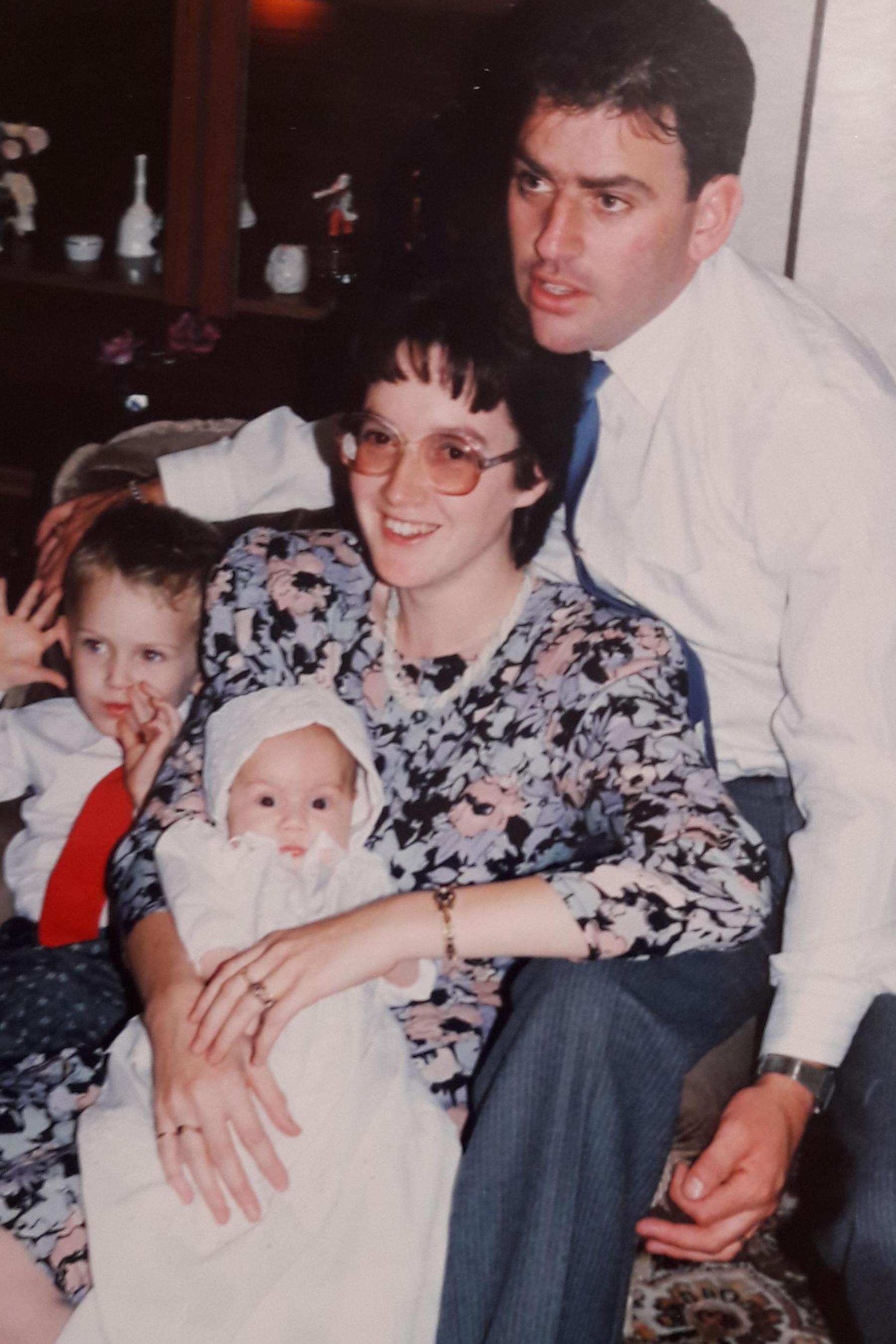 Family pose for photograph in the 1990s