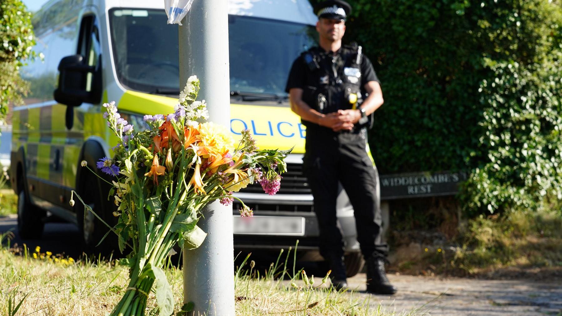 Flowers and a police vehicle outside the home of 78-year-old former government minister Ann Widdecombe after she was found dead, in Haytor, Britain, July 11, 2026. 