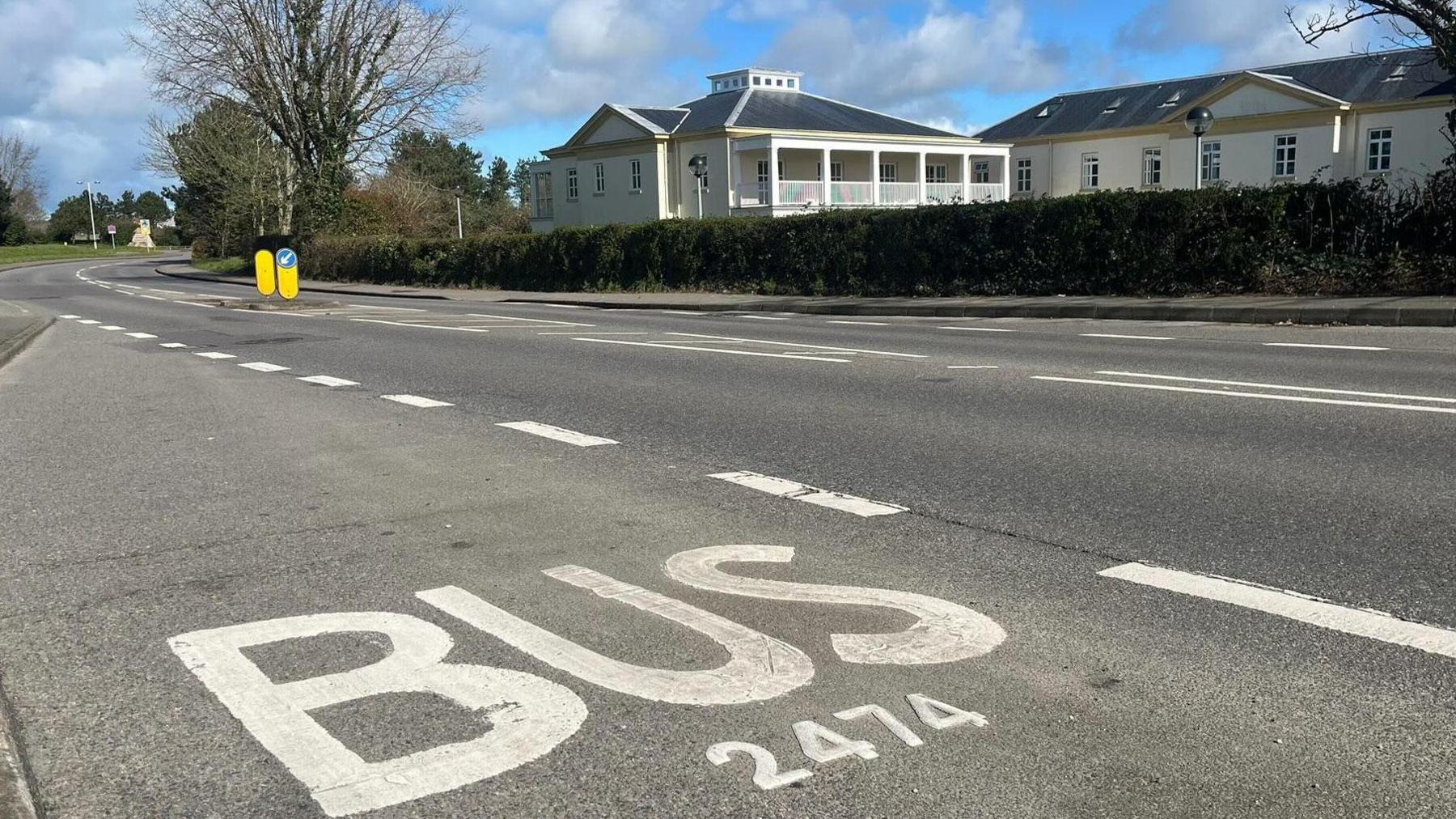 A road with the word bus painted on the surface in white