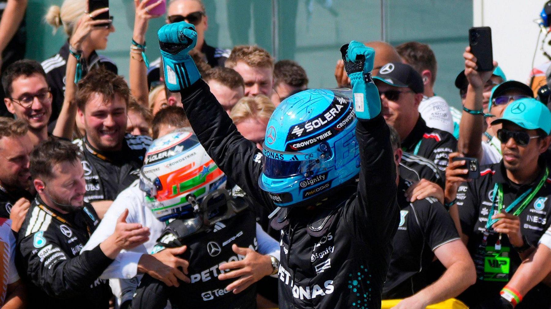 George Russell holds both arms above his head in celebration after winning the Canadian Grand Prix