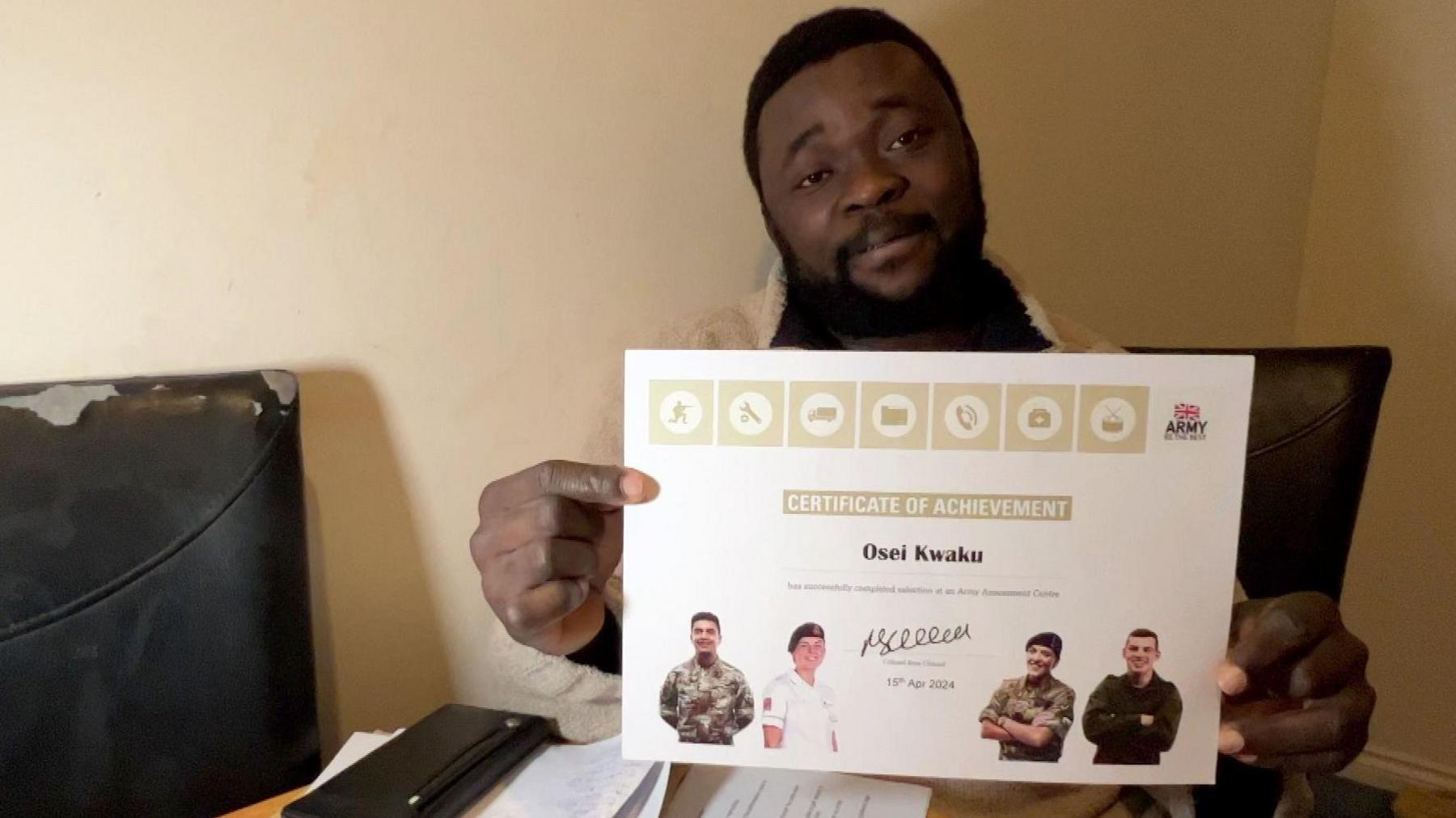 Osei shows off the certificate he received from the army after passing a selection course.