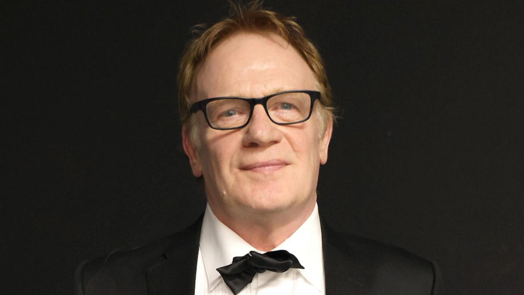 Llun o Mark Lewis Jones mewn tuxedo