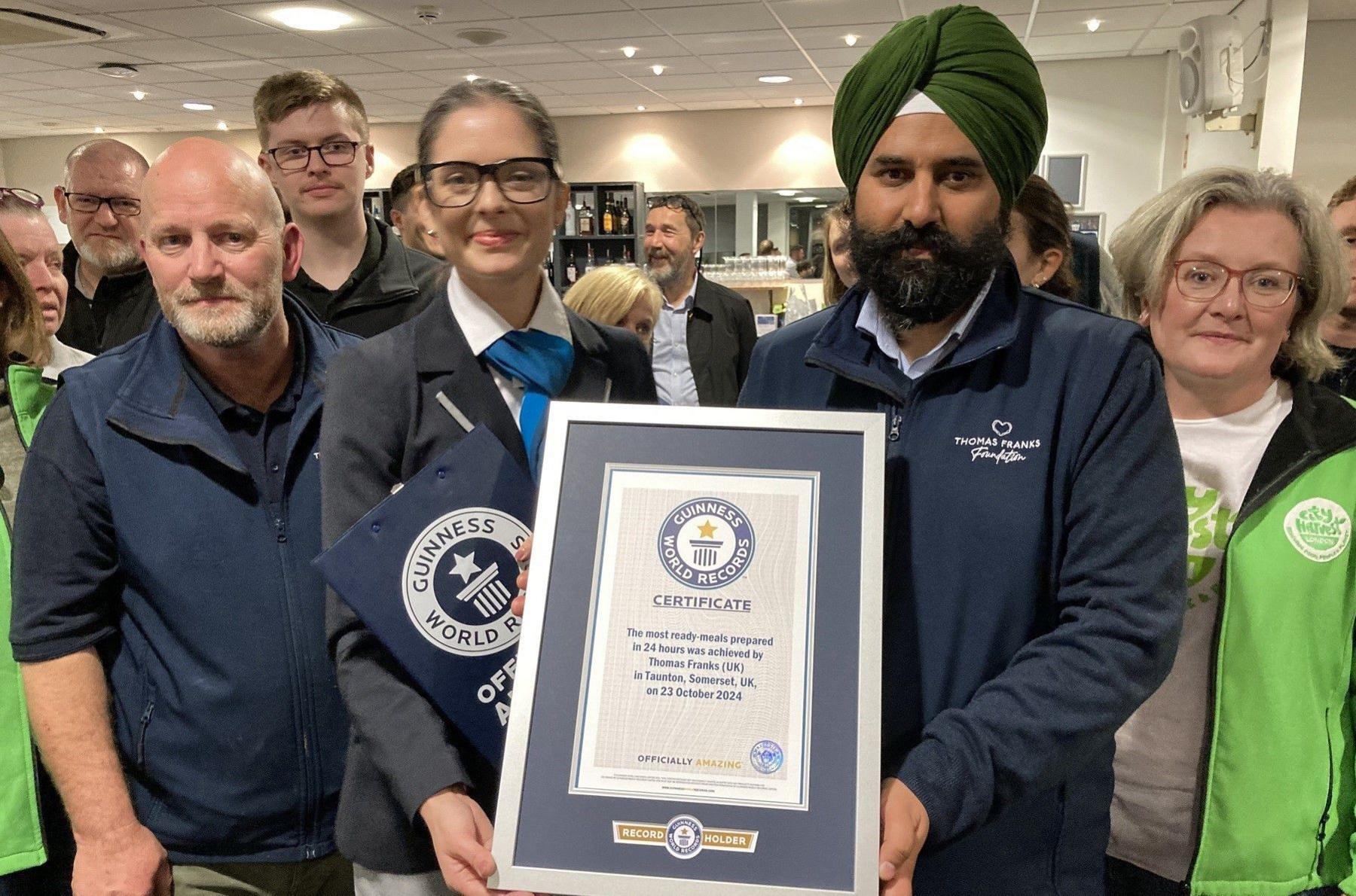 A group of people hold a framed certificate as they pose for the camera at the the Big Cook challenge in Taunton in Somerset