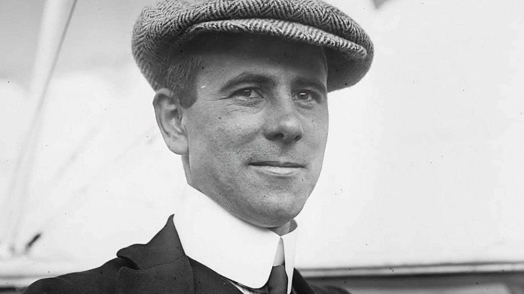 Alliott Verdon-Roe wearing a tweed flat cap and shirt and tie