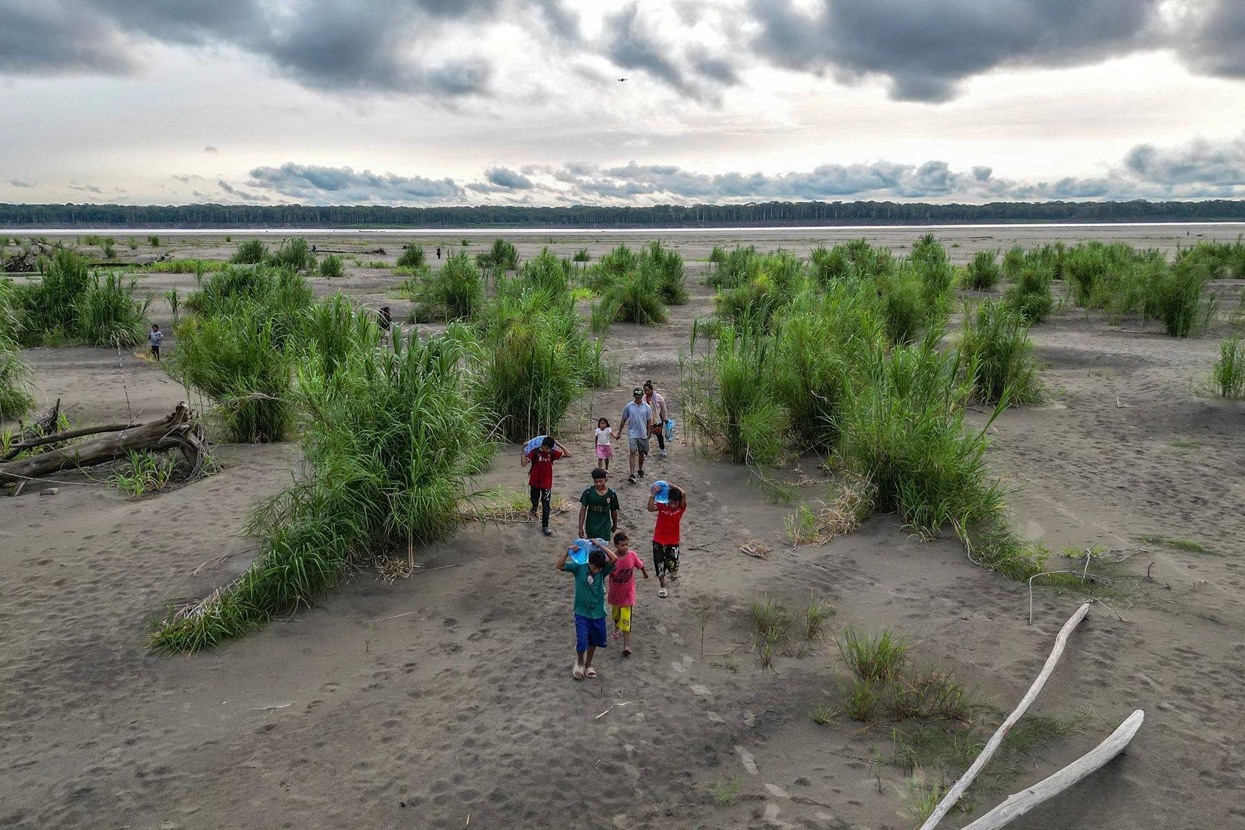 Aerial view of Yagua Indigenous people carrying water and other goods due to the low level of the Amazon River at Isla de los Micos, Amazonas department, Colombia, on October 4, 2024. 