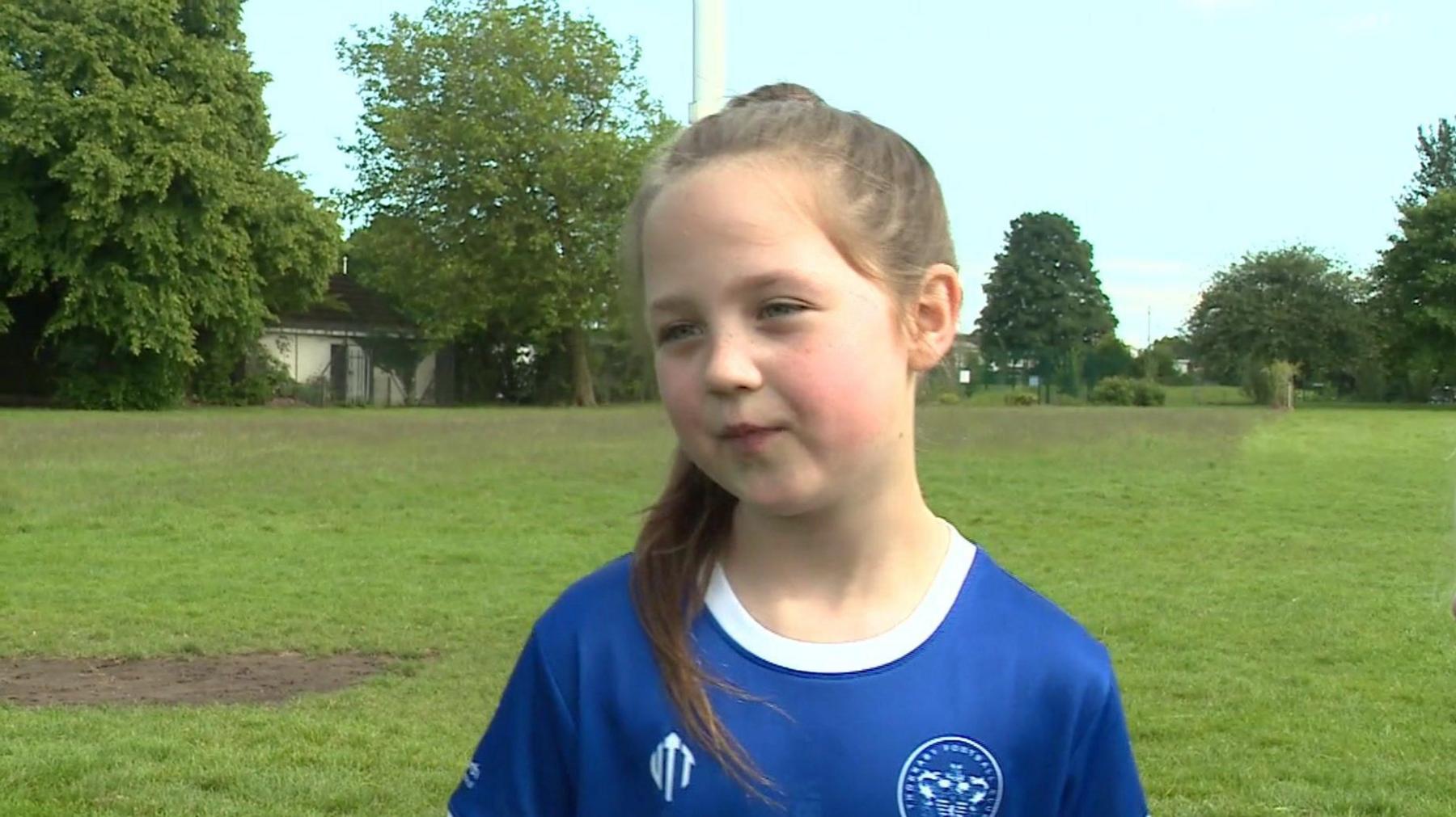 Isabelle being interviewed in her blue club shirt