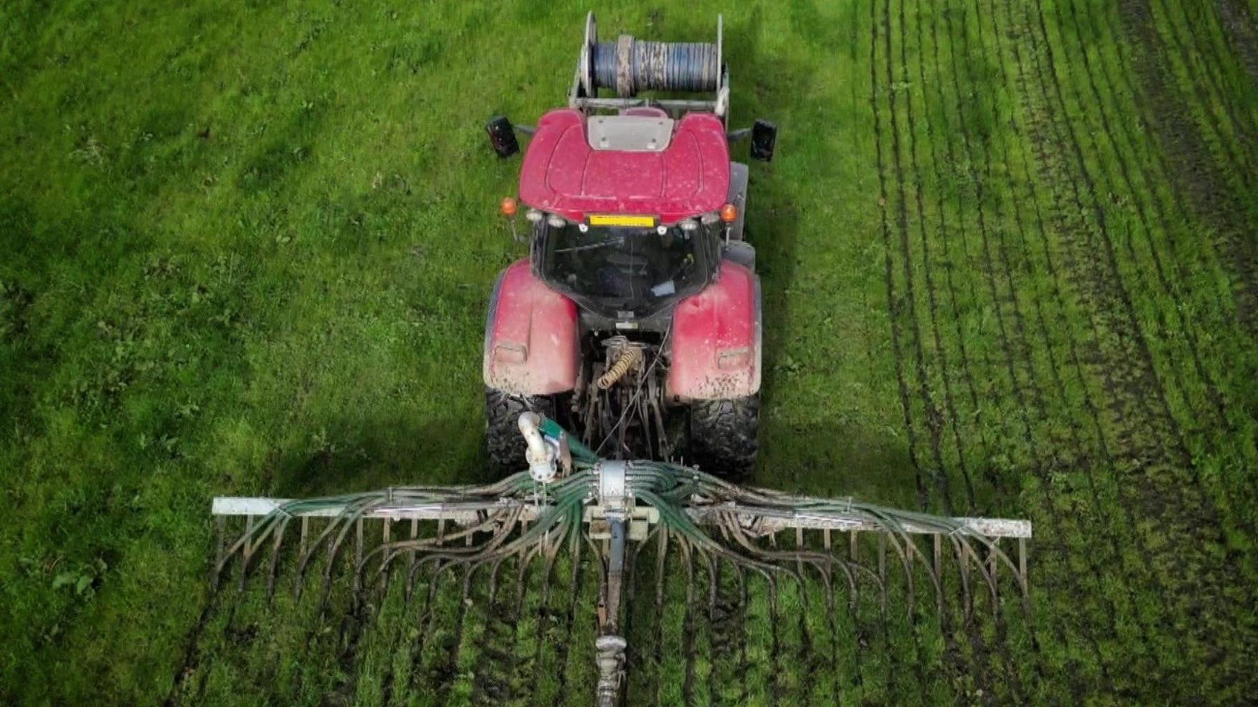 Tractor yn gwasgaru slyri