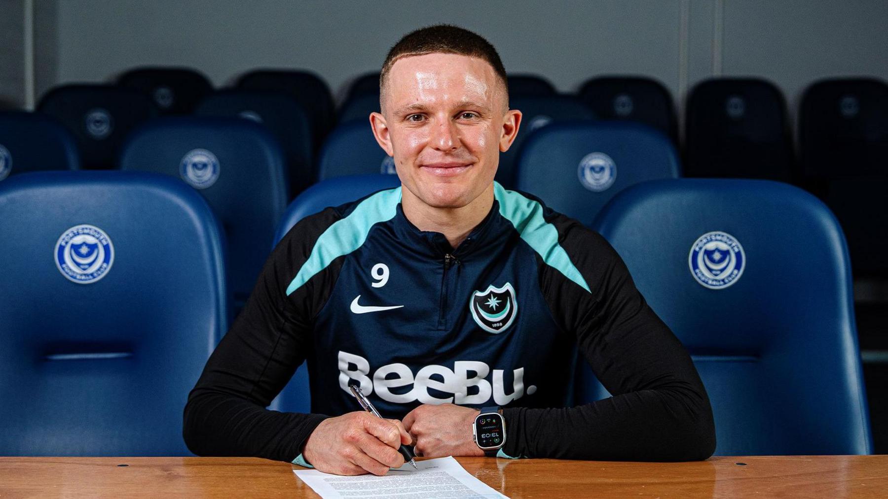 Portsmouth striker Colby Bishop poses for a photo as he signs his new contract