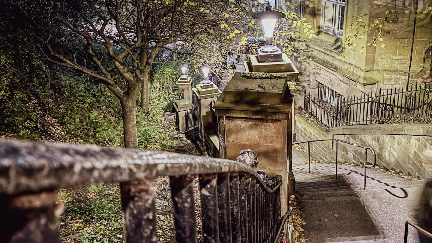 Looking down a long steep flight of stone stairs that bend off to the left.