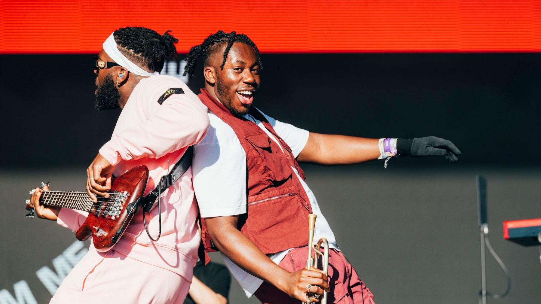 TJ Foleoso (left) and Ife Ogunjobi (right) of Ezra Collective share an on-stage moment at the 2024 Glastonbury Festival