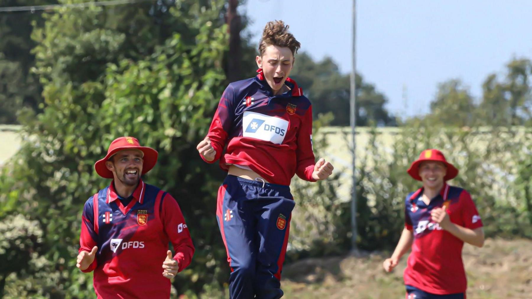 Jersey players rush in to congratulate a jumping team-mate during their 50-over match against Kenya