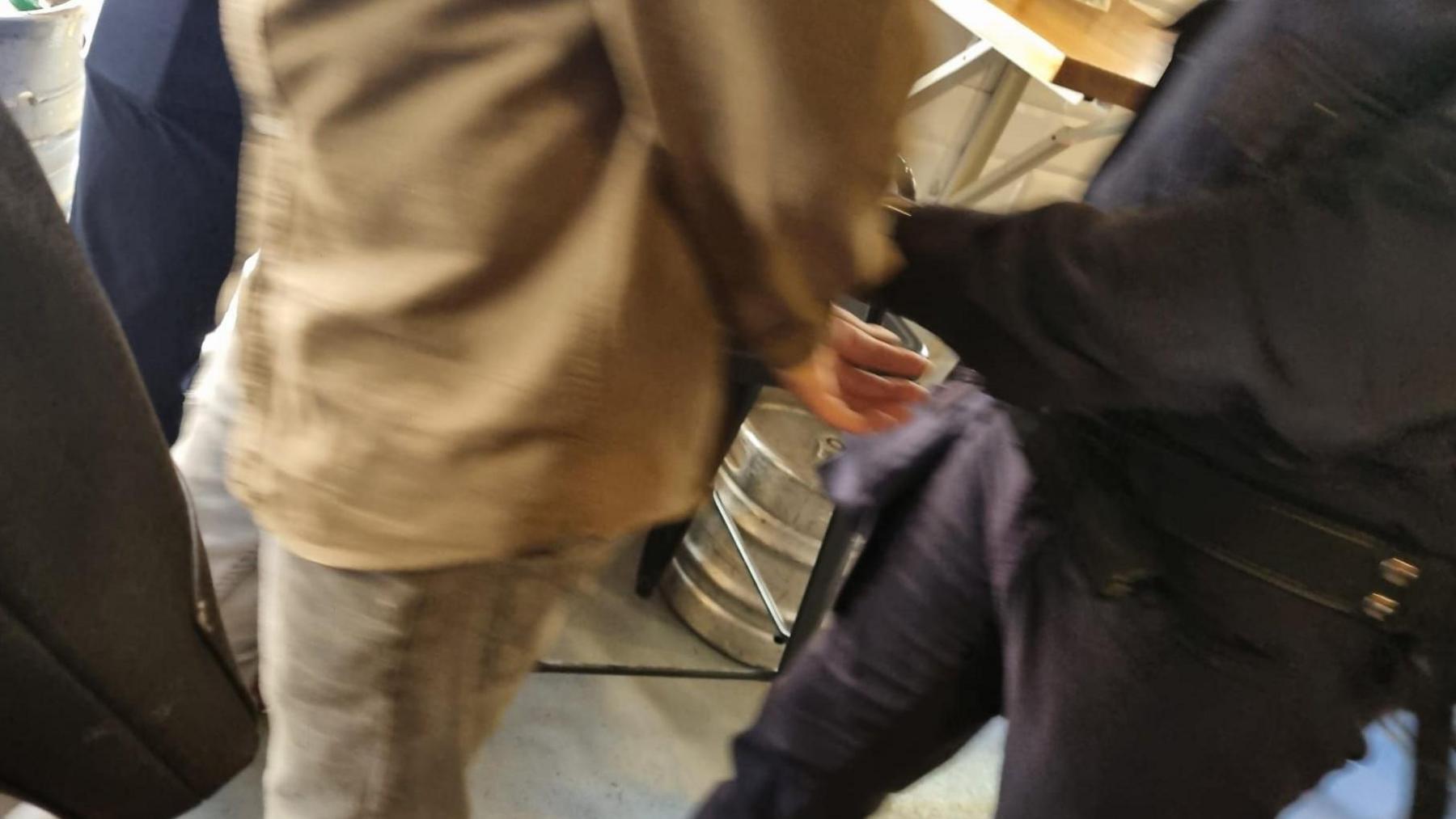 A man in handcuffs after Sergeant Eren Emin along with other off duty British police officers chased after him for allegedly stealing from a restaurant in Barcelona