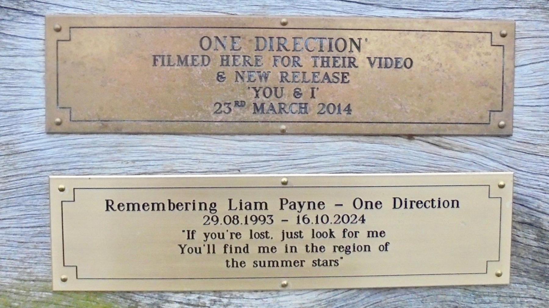 Two plaques on a wooden pier marking both One Direction filming a music video in Clevedon and remembering band member Liam Payne.