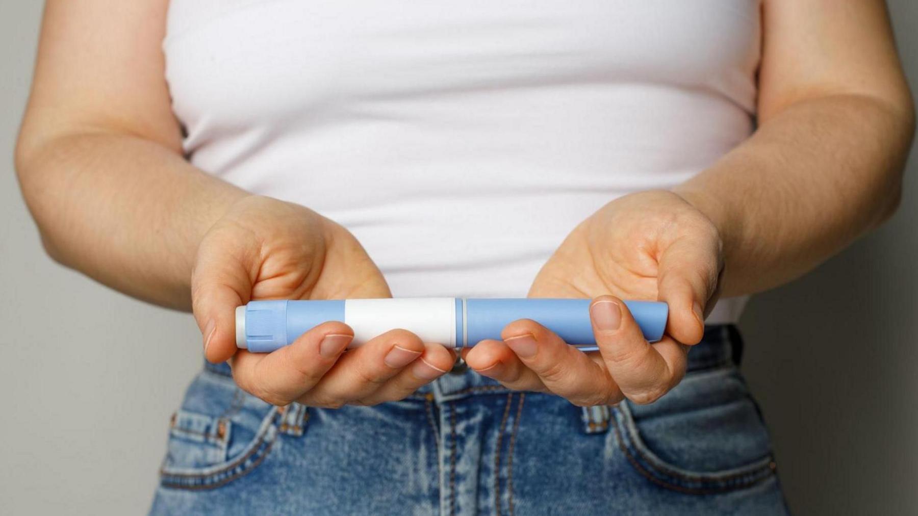 Woman holding an obesity injection product