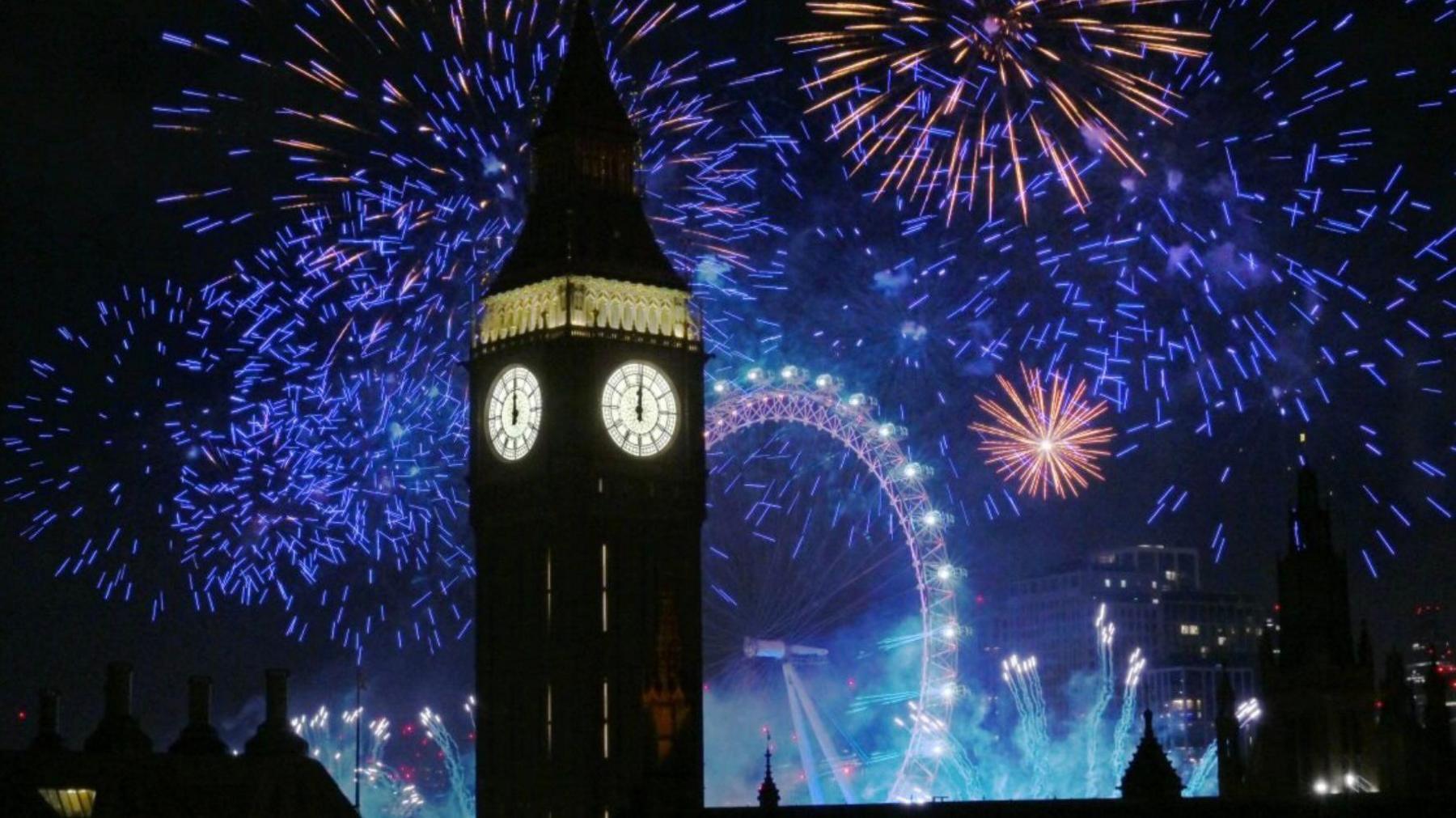 Fireworks light up the sky over Elizabeth Tower, also known as Big Ben, and the London Eye in central London during the New Year celebrations