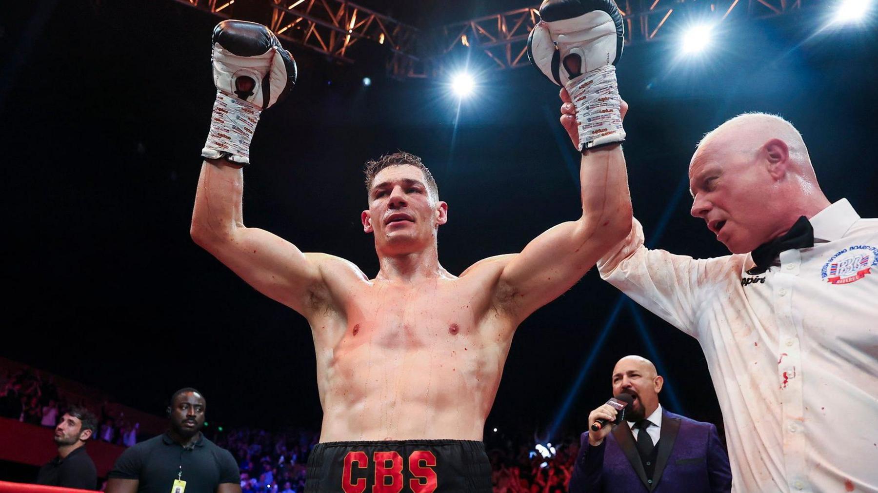 Chris Billam-Smith has his arms held aloft by a referee