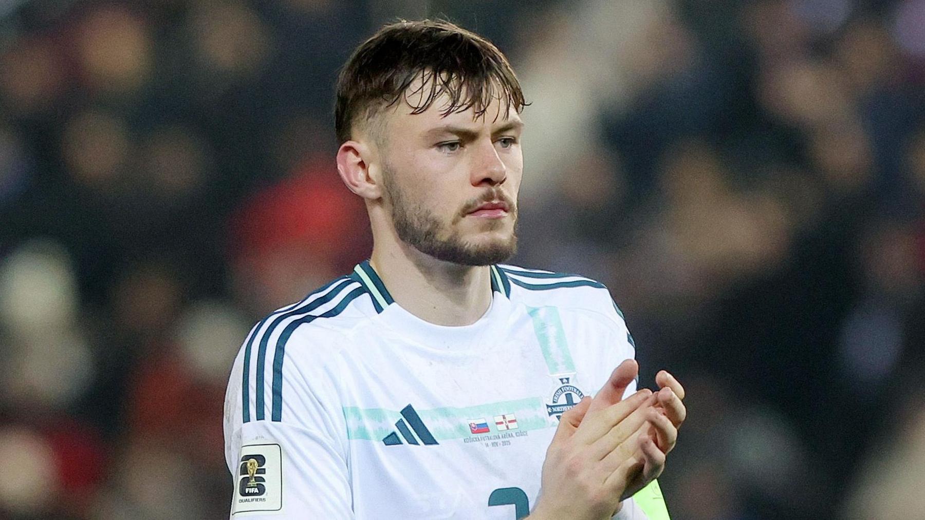 Conor Bradley applauds supporters in Kosice