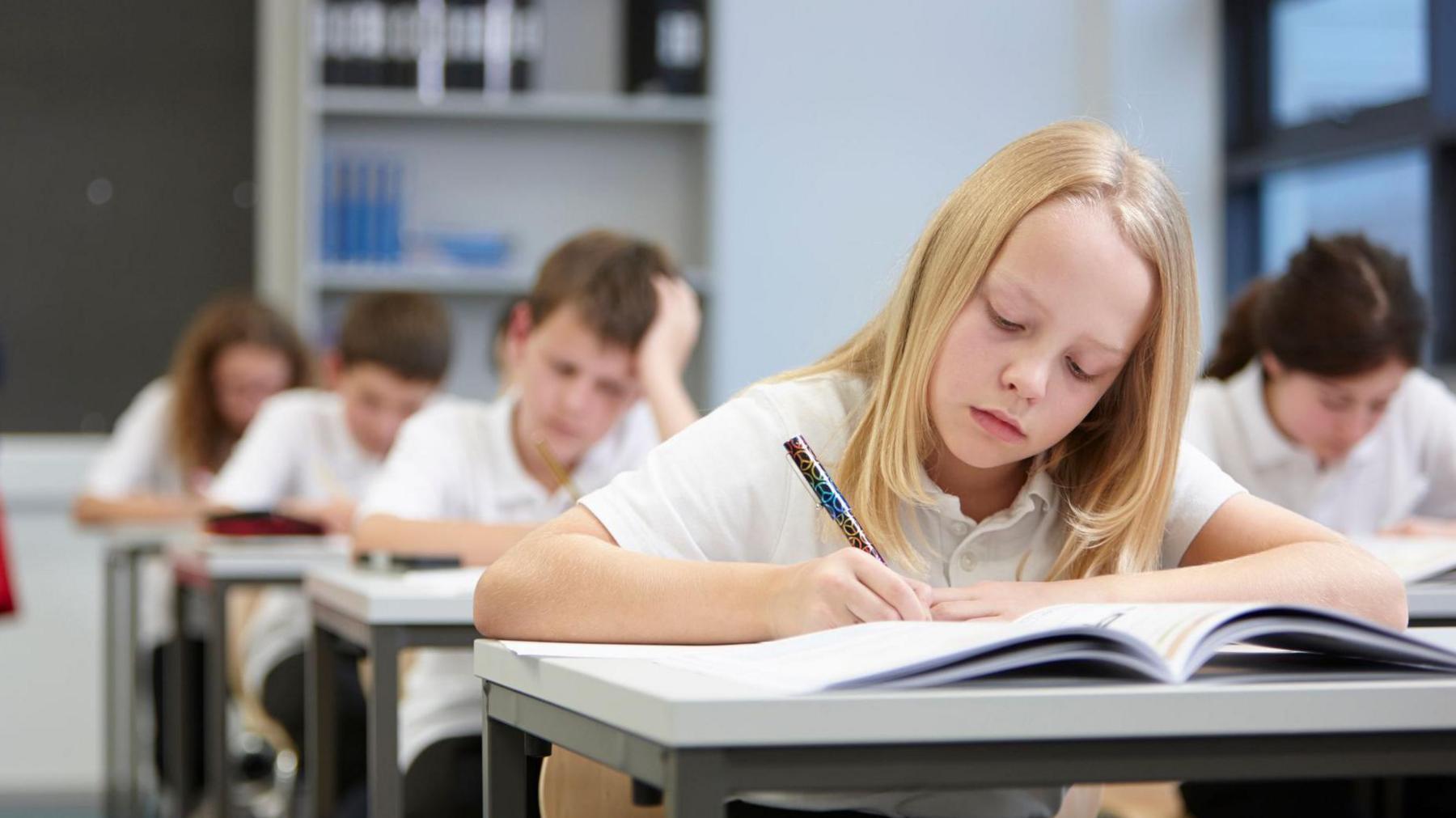 Pupil takes exam in classroom.