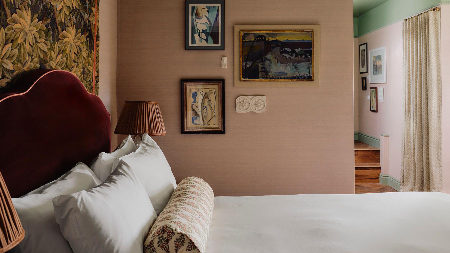 A made up bed in a room with cream walls and a green ceiling.