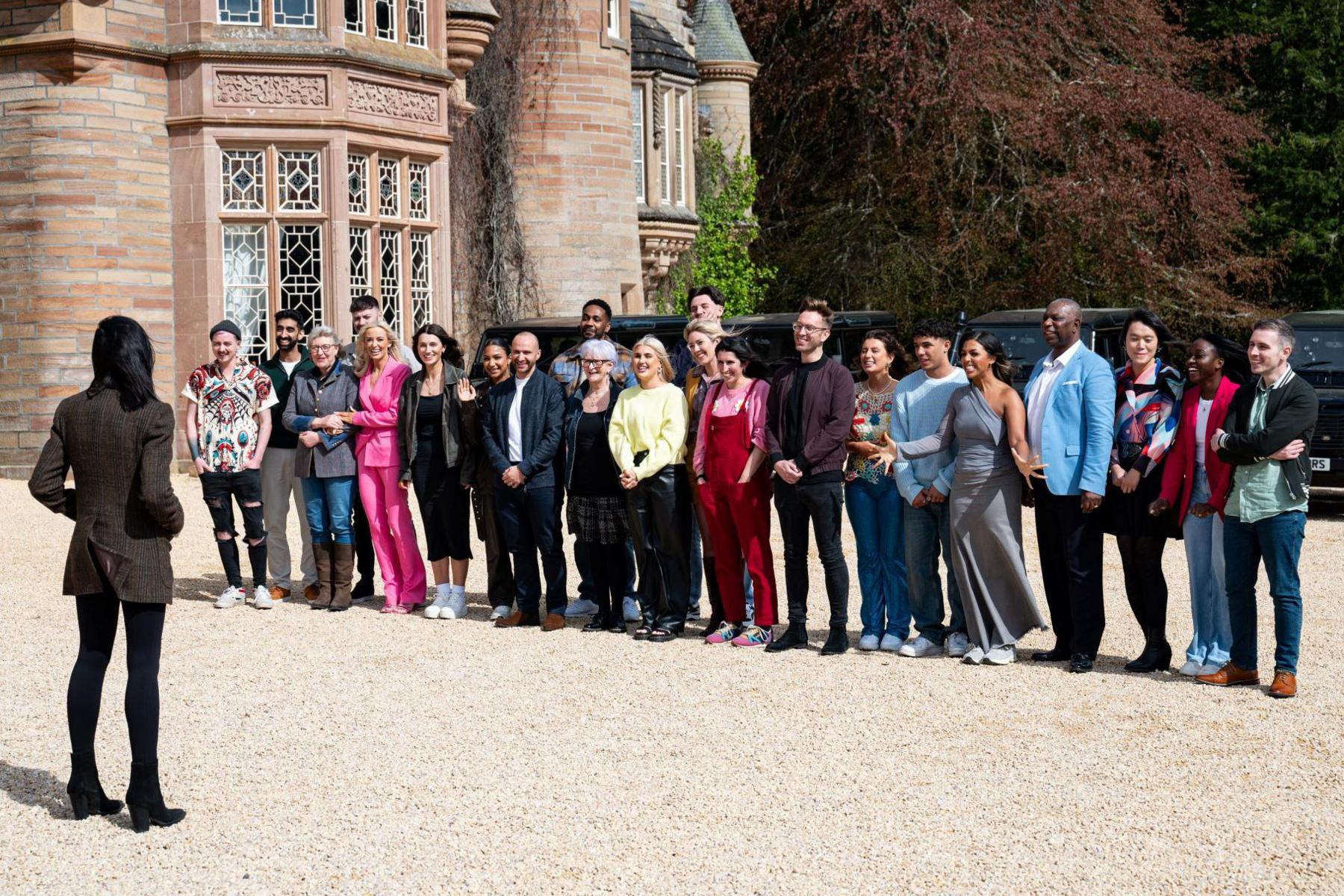 Claudia stands in front of series three's contestants. They are all standing in front of the castle.